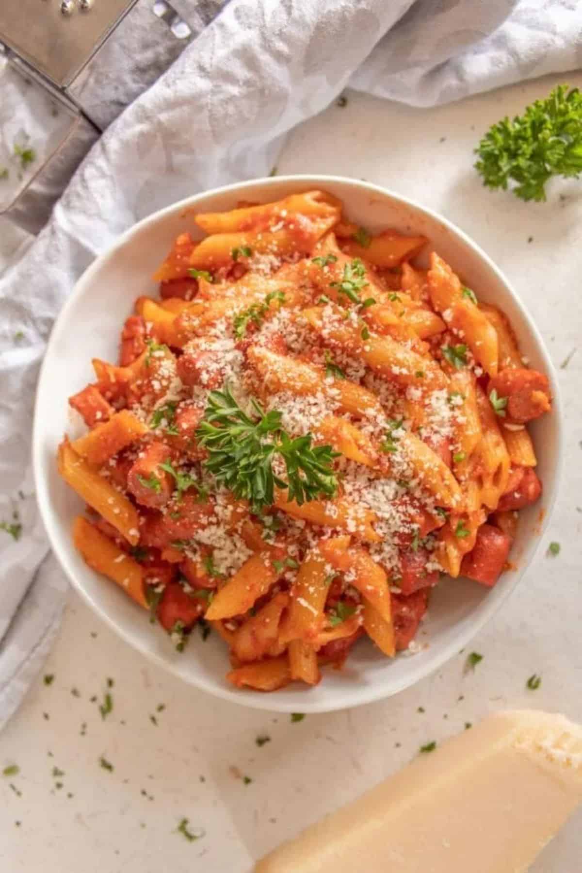 Delicious hot dog pasta in a white bowl.