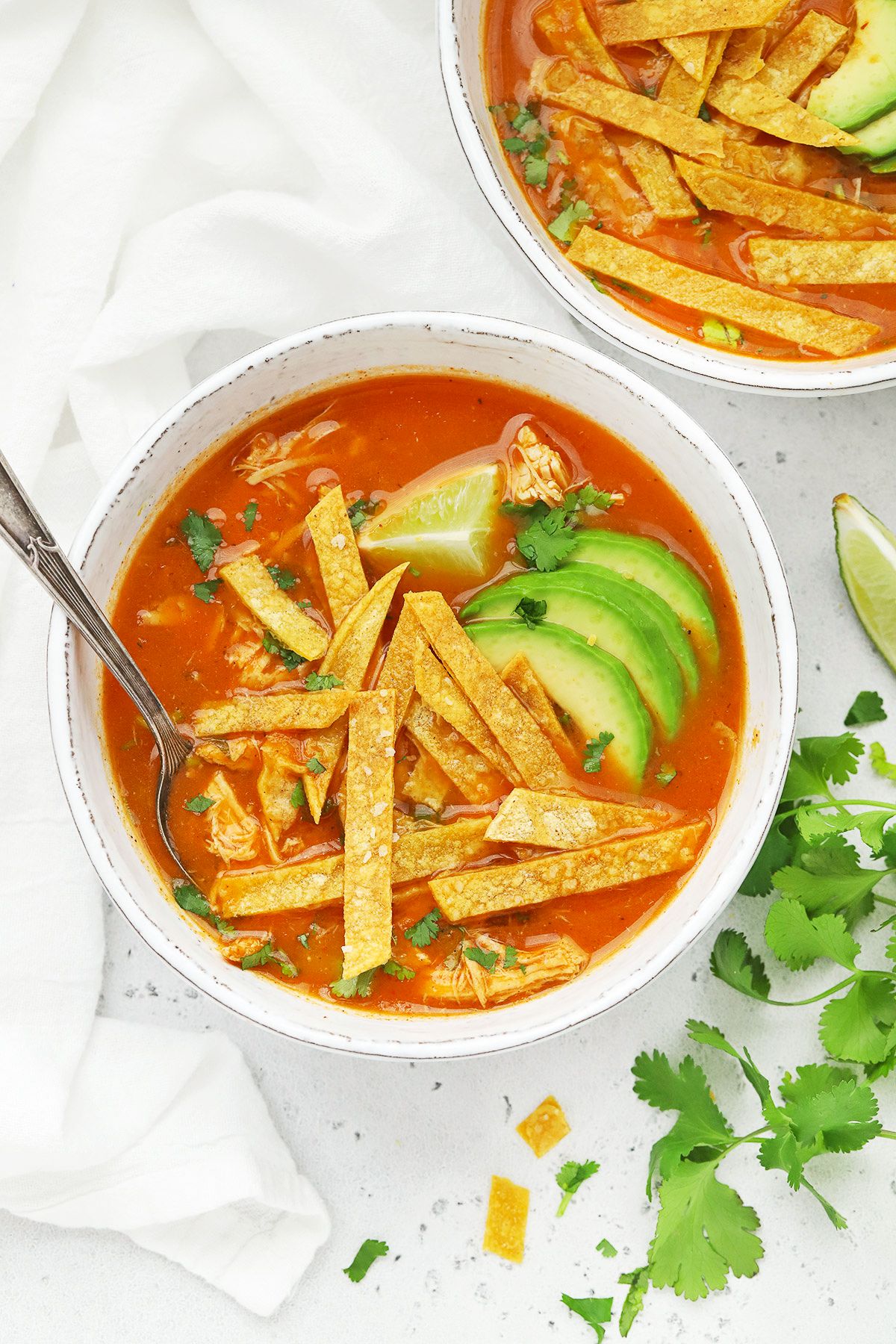 Healthy chicken tortilla soup in a bowl with a spoon.