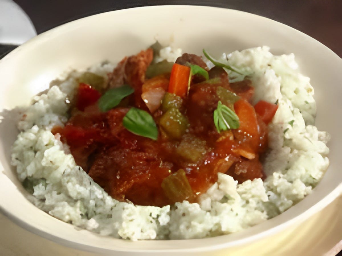 Scrumptious deconstructed sweet sausage stuffed peppers with rice in a white bowl.