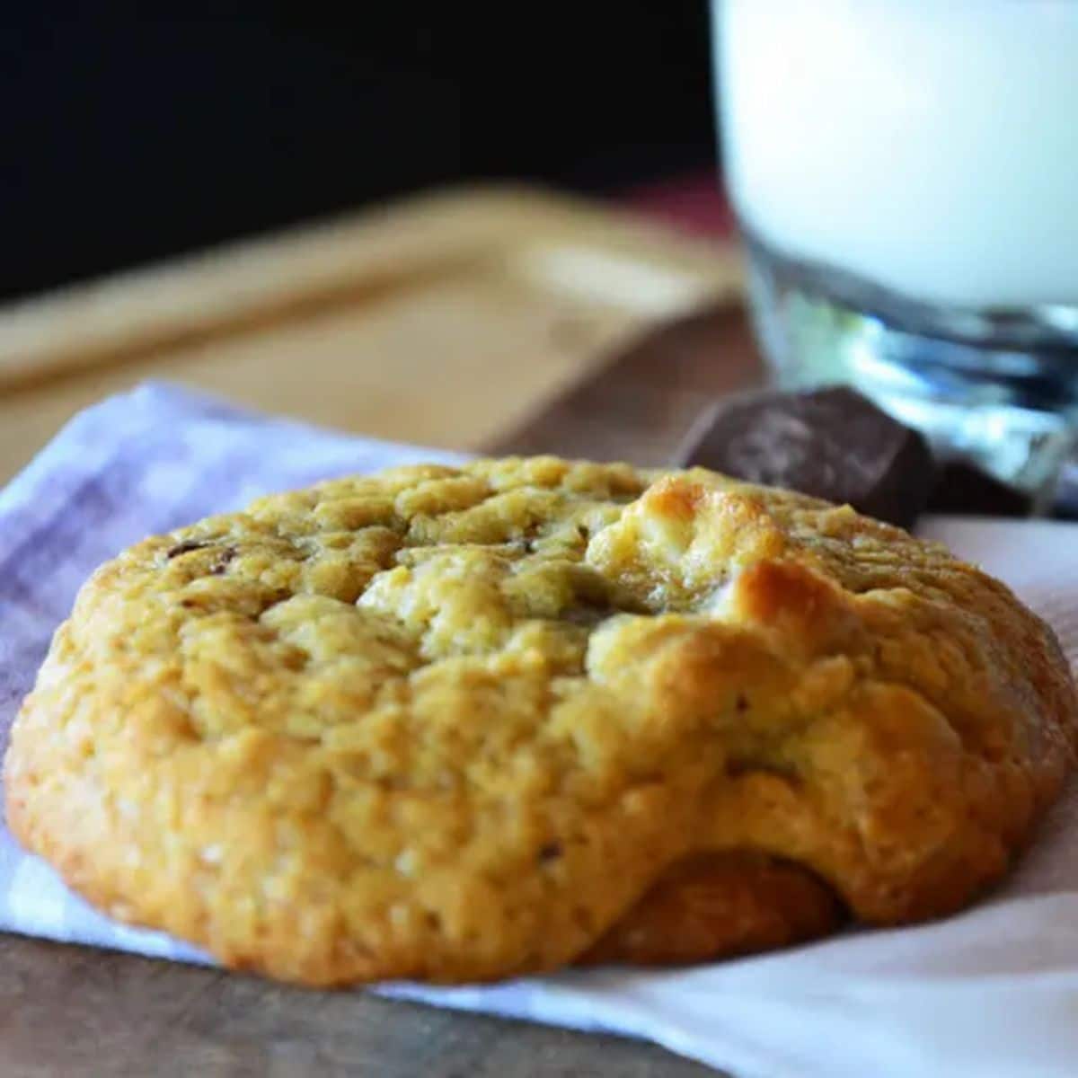 Crunchy brazil nut chocolate chunk cookie on a wooden tray.