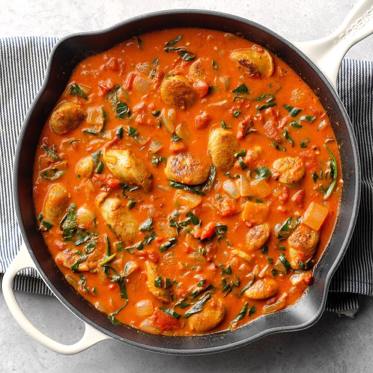 Juicy chicken sausage tomato coconut curry in a skillet.