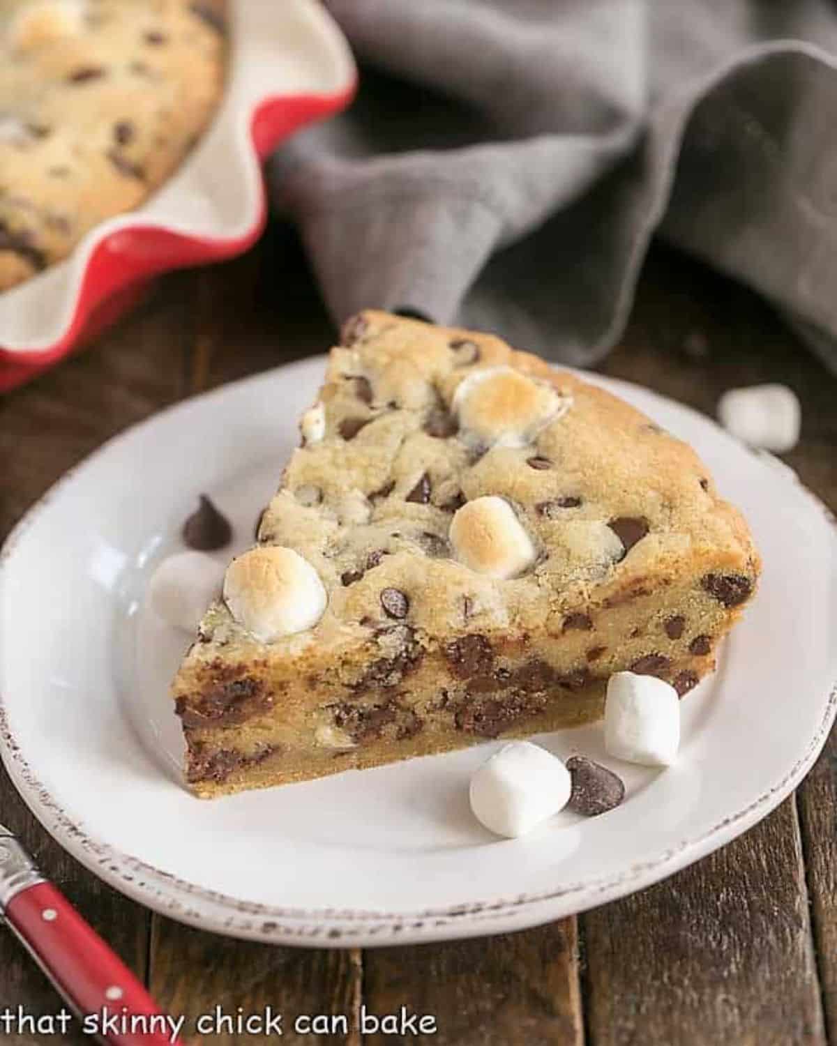 A piece of gooey chocolate chip pie on a white plate.