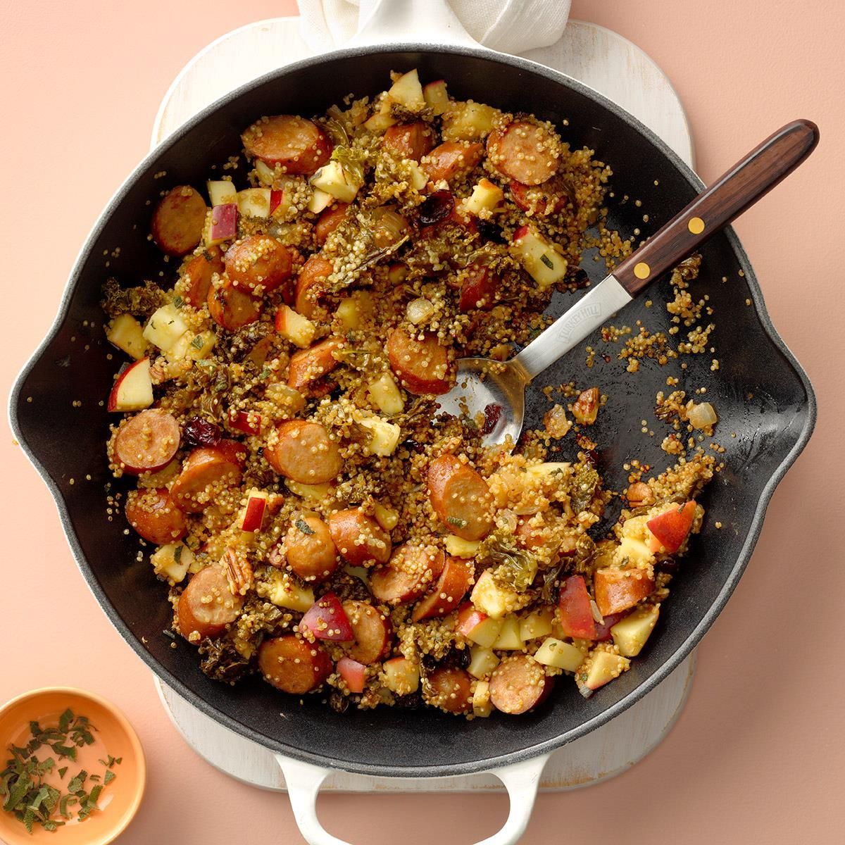 Flavorful apple cider chicken quinoa in a skillet with a spatula.