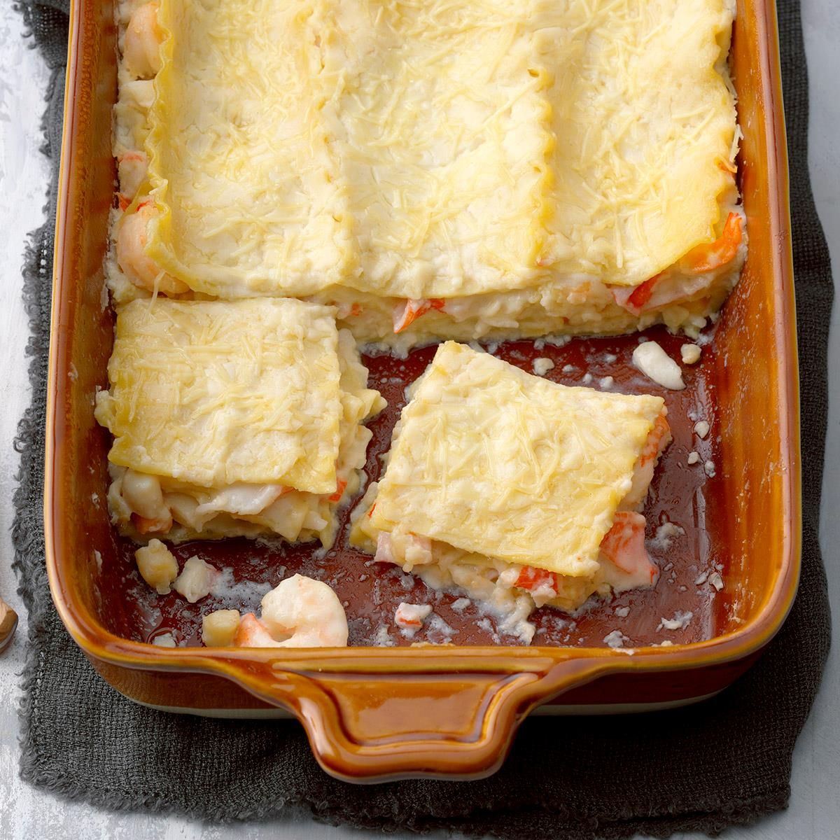 Tasty seafood lasagna in an orange casserole.