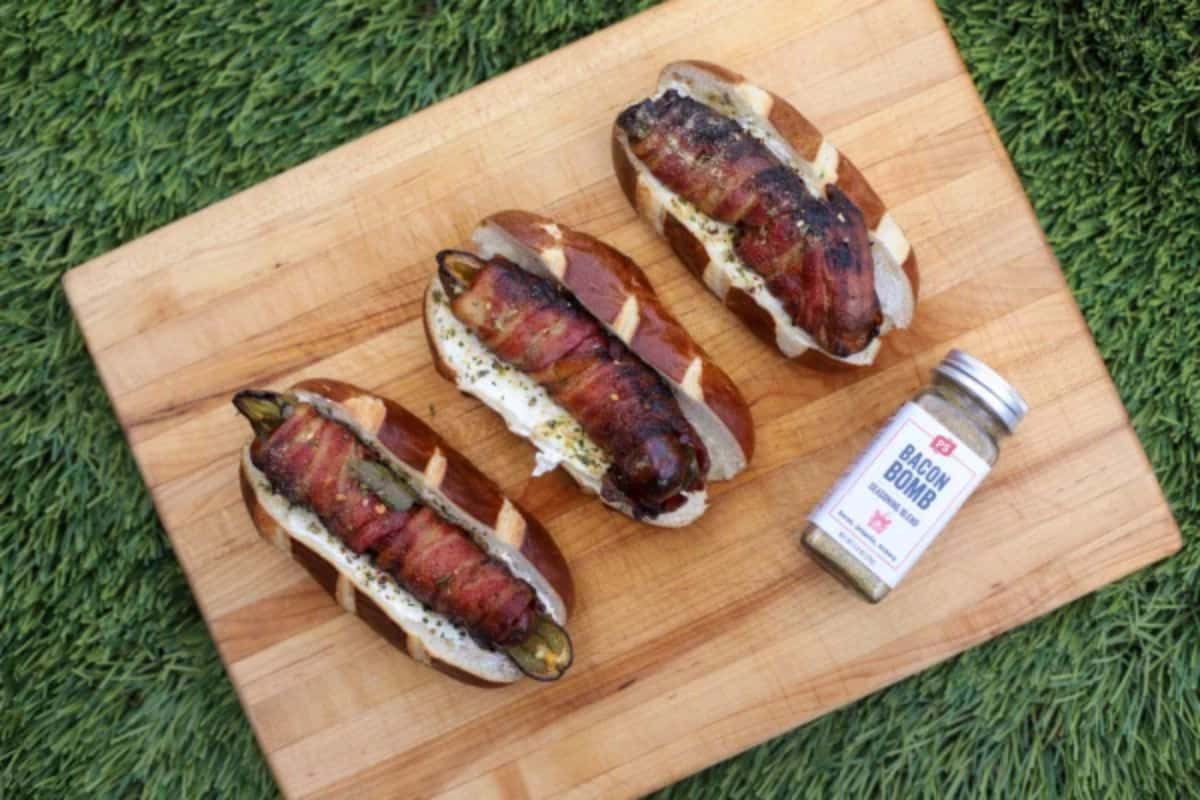 Scrumptious jalapeno popper hot dogs on a wooden tray.