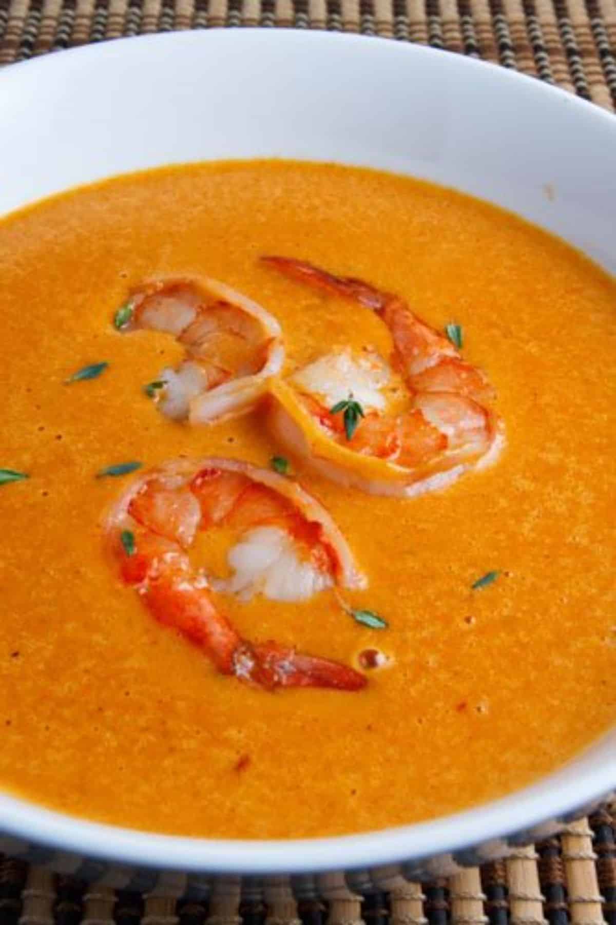 Juicy shrimp bisque in a white bowl.
