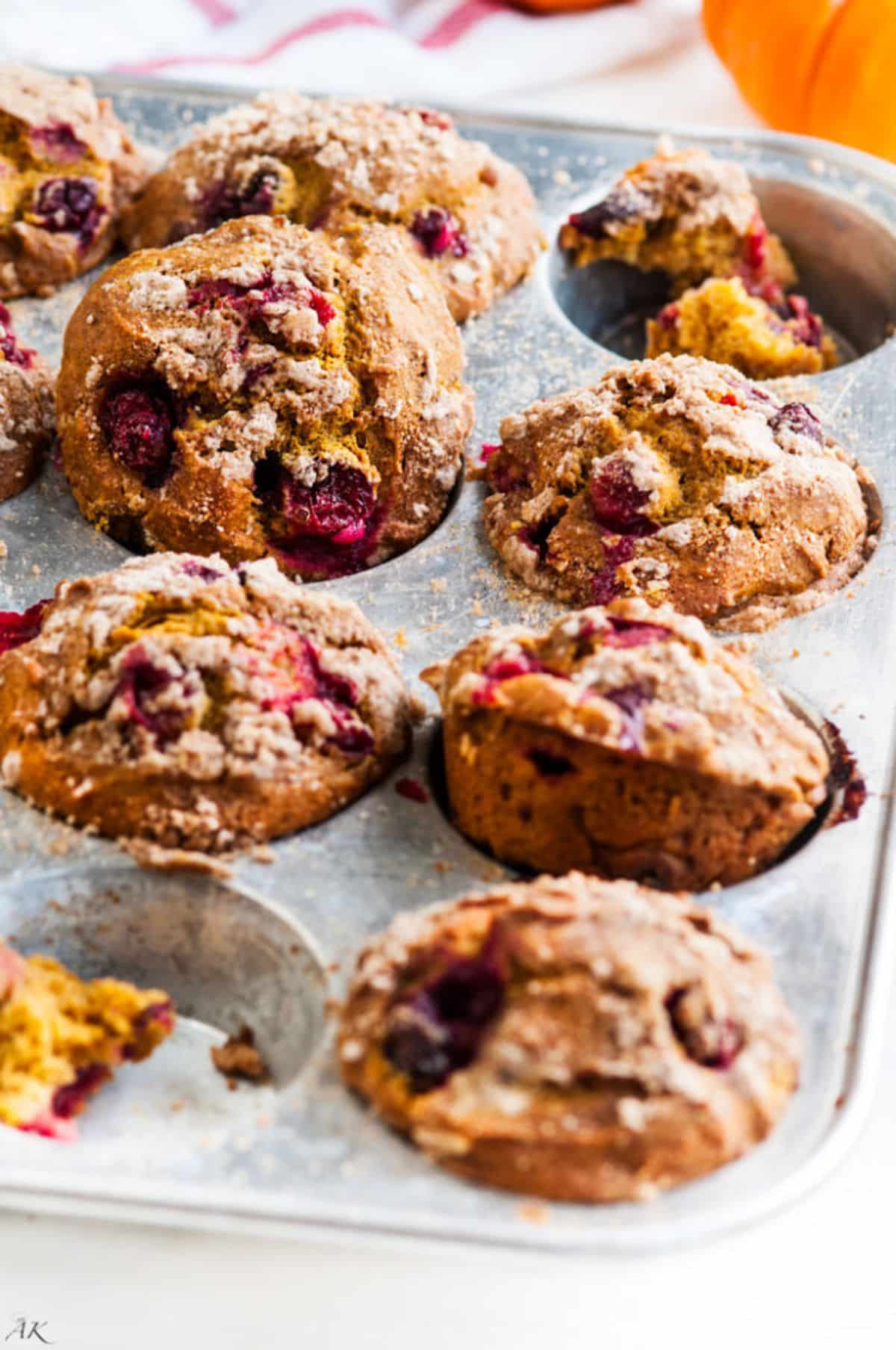Flavorful pumpkin spice cranberry muffins in a muffin tray.