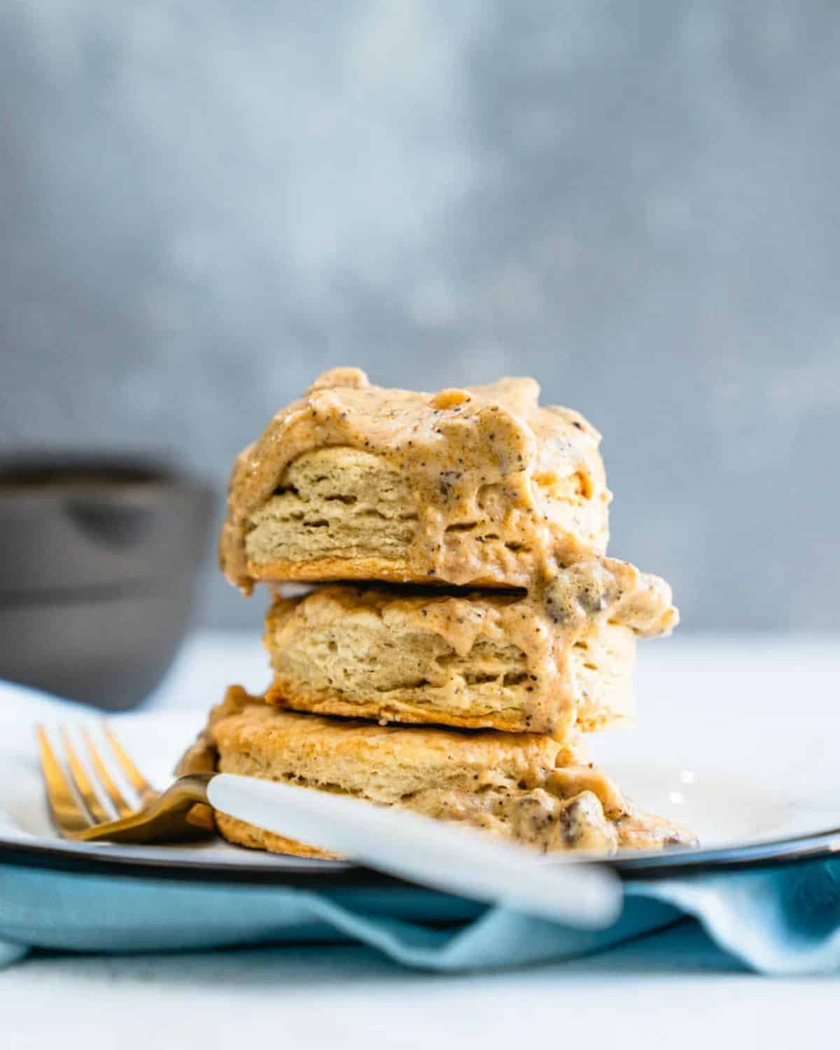 A pile of vegan biscuits and gravy on a plate with a fork.