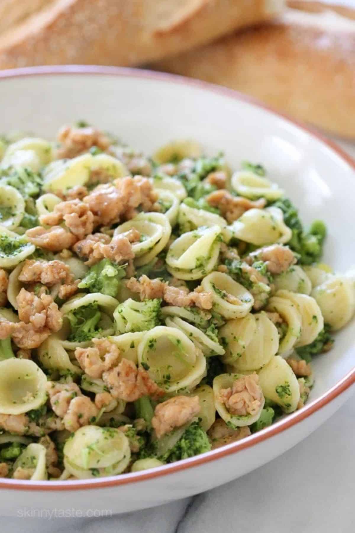 Healthy orecchiette pasta with chicken sausage and broccoli in a bowl.