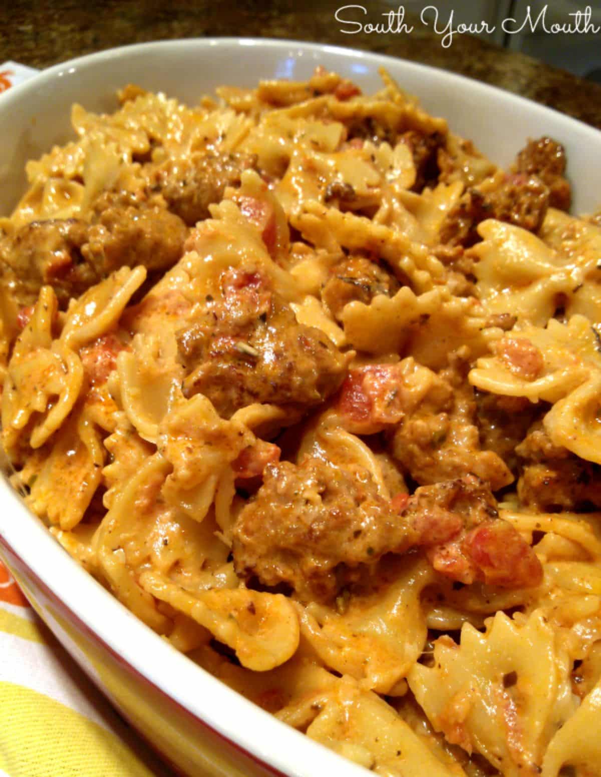 Creamy italian sausage pasta toss in a white casserole.