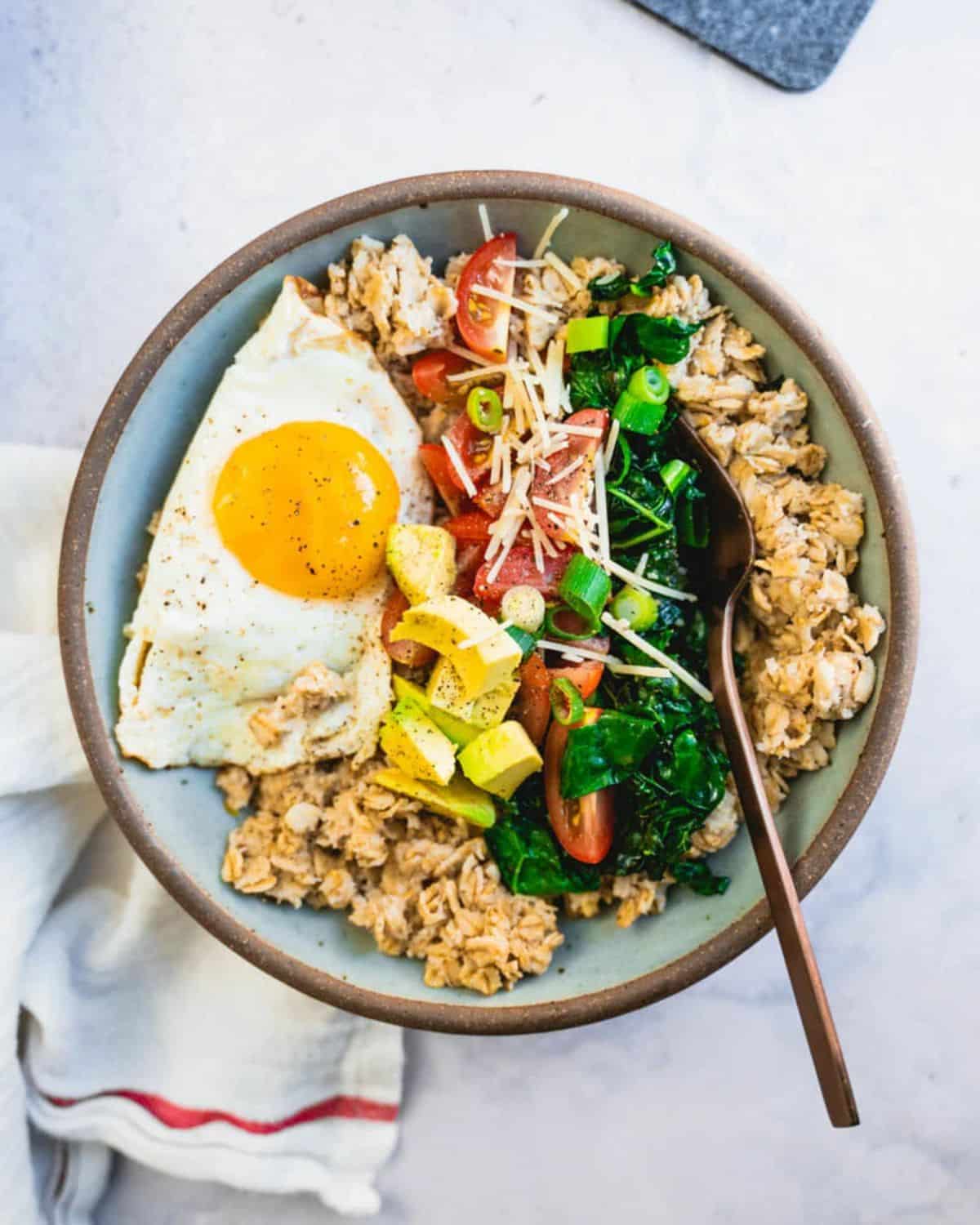 Delicious savory oatmeal in a bowl with a spoon.