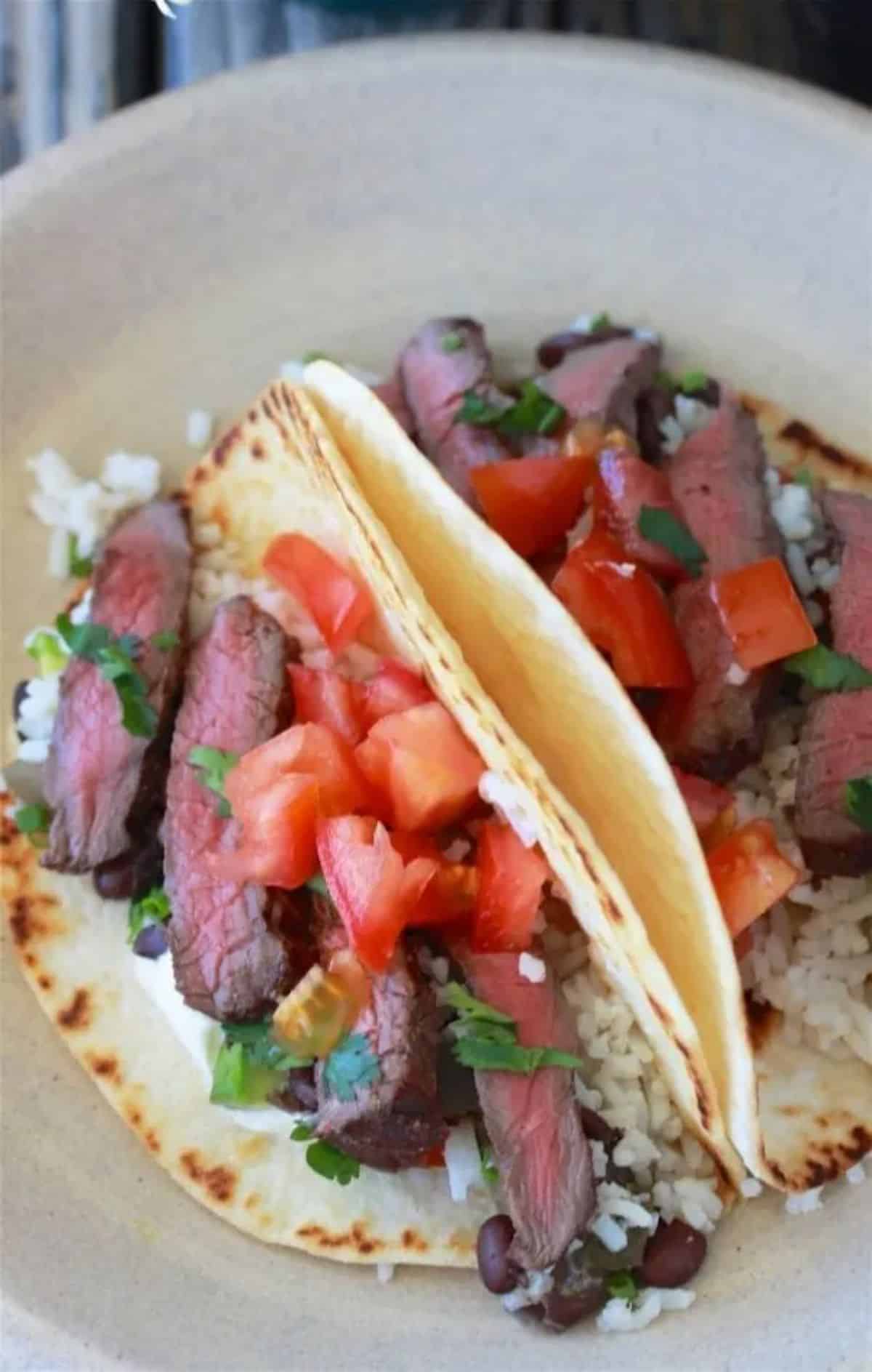 Delicious spicy tequila elk steak fajitas in a white bowl.