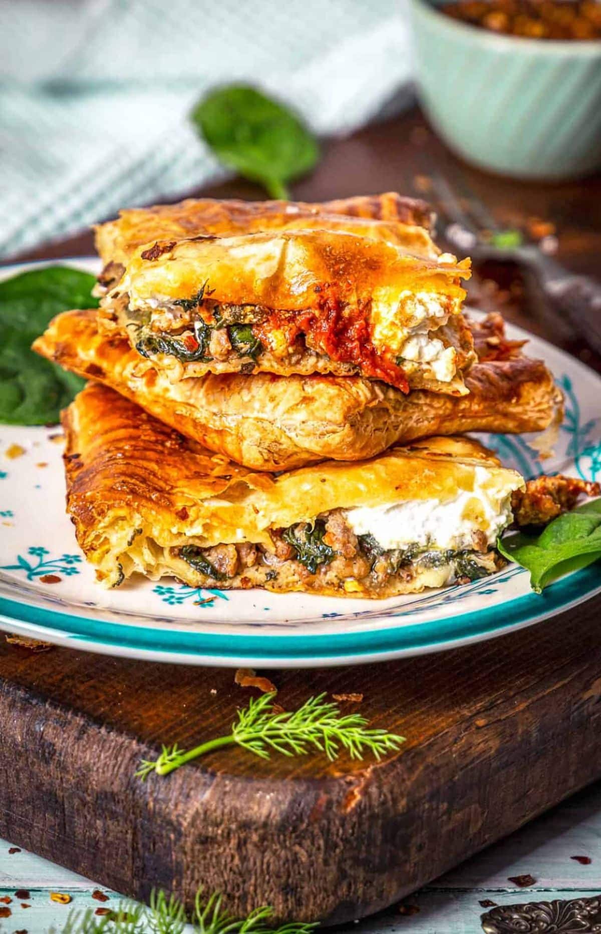 Scrumptious spicy italian sausage and spinach slab pie on a colorful plate.