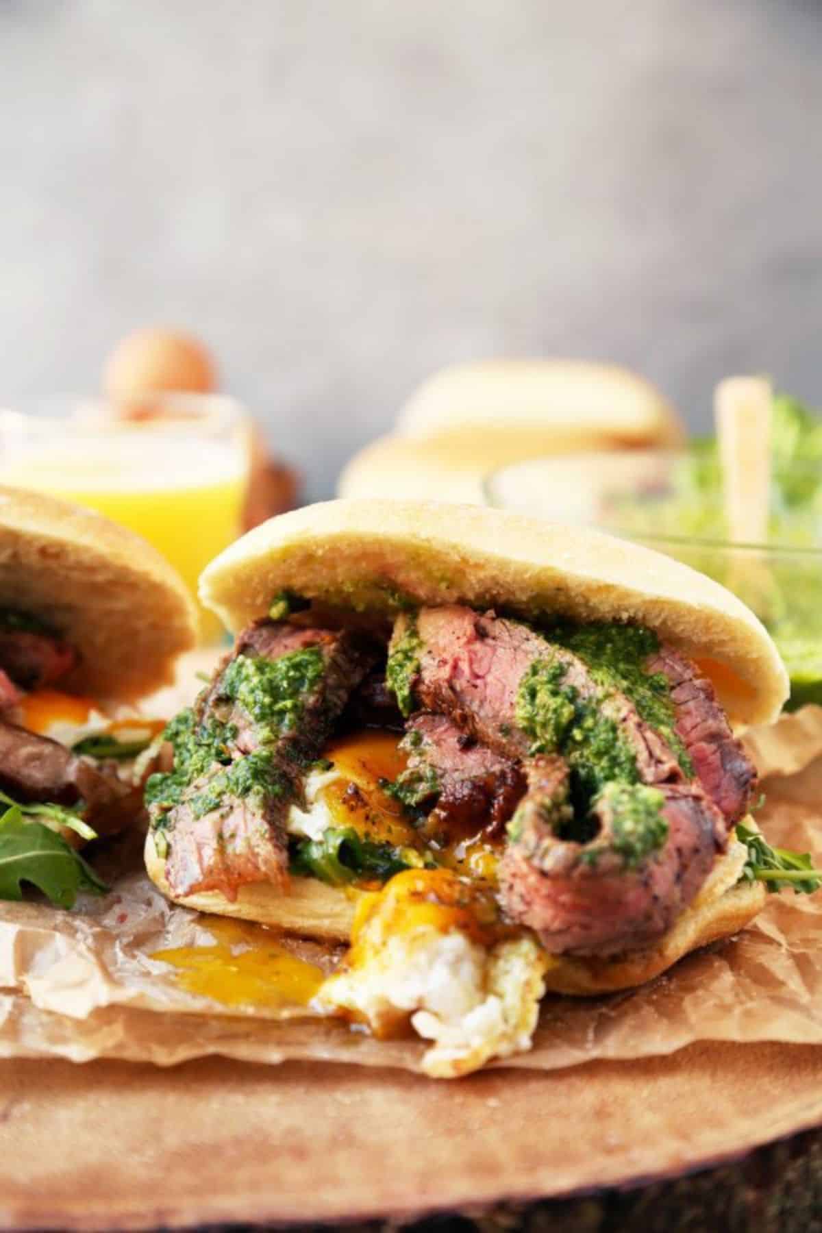 Mouth-watering steak and egg sandwich on a wooden tray.