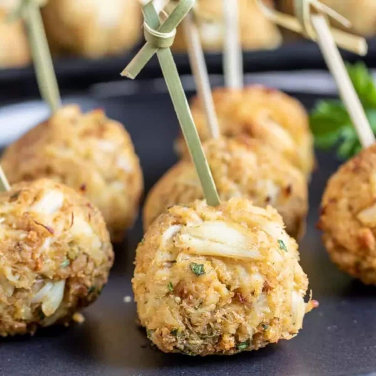 Tasty crab balls on a black tray.