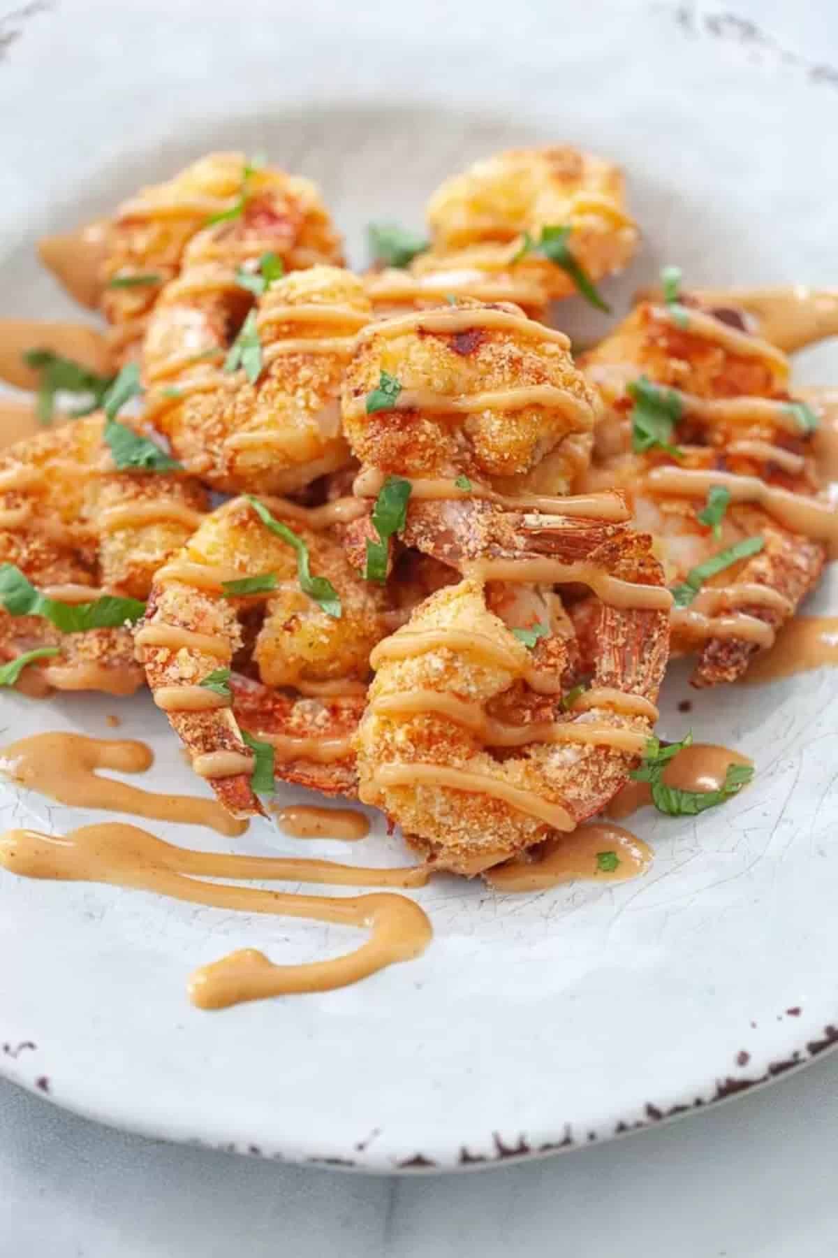 Crispy keto bang bang shrimp on a white plate.