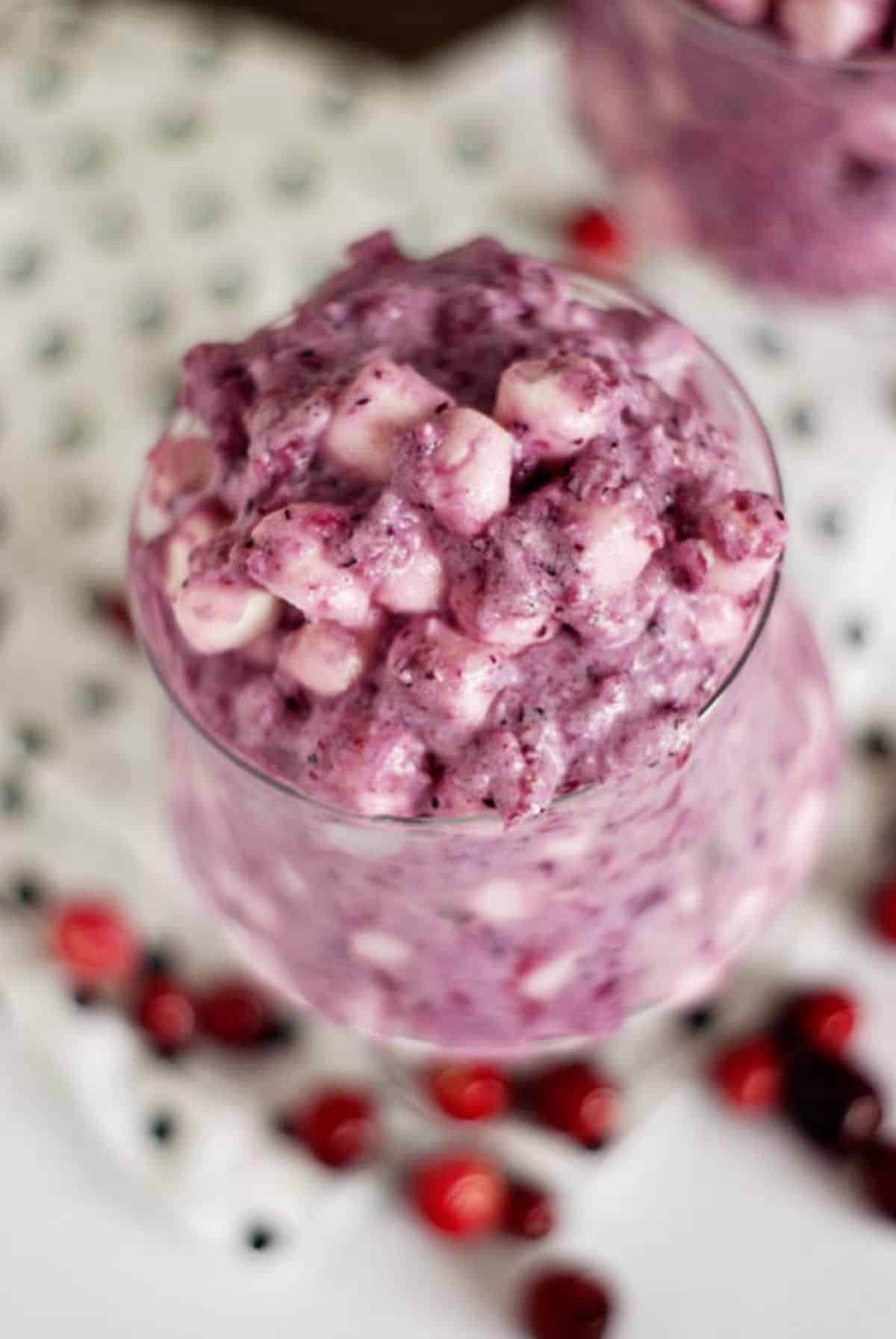 Mouth-watering cranberry fluff salad in a tall glass.