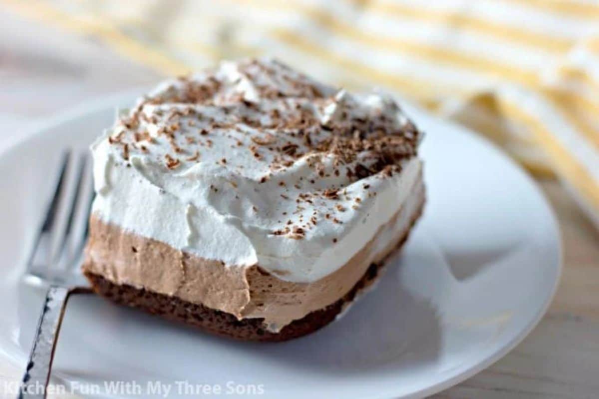 Scrumptious french silk brownie on a white plate with a fork.