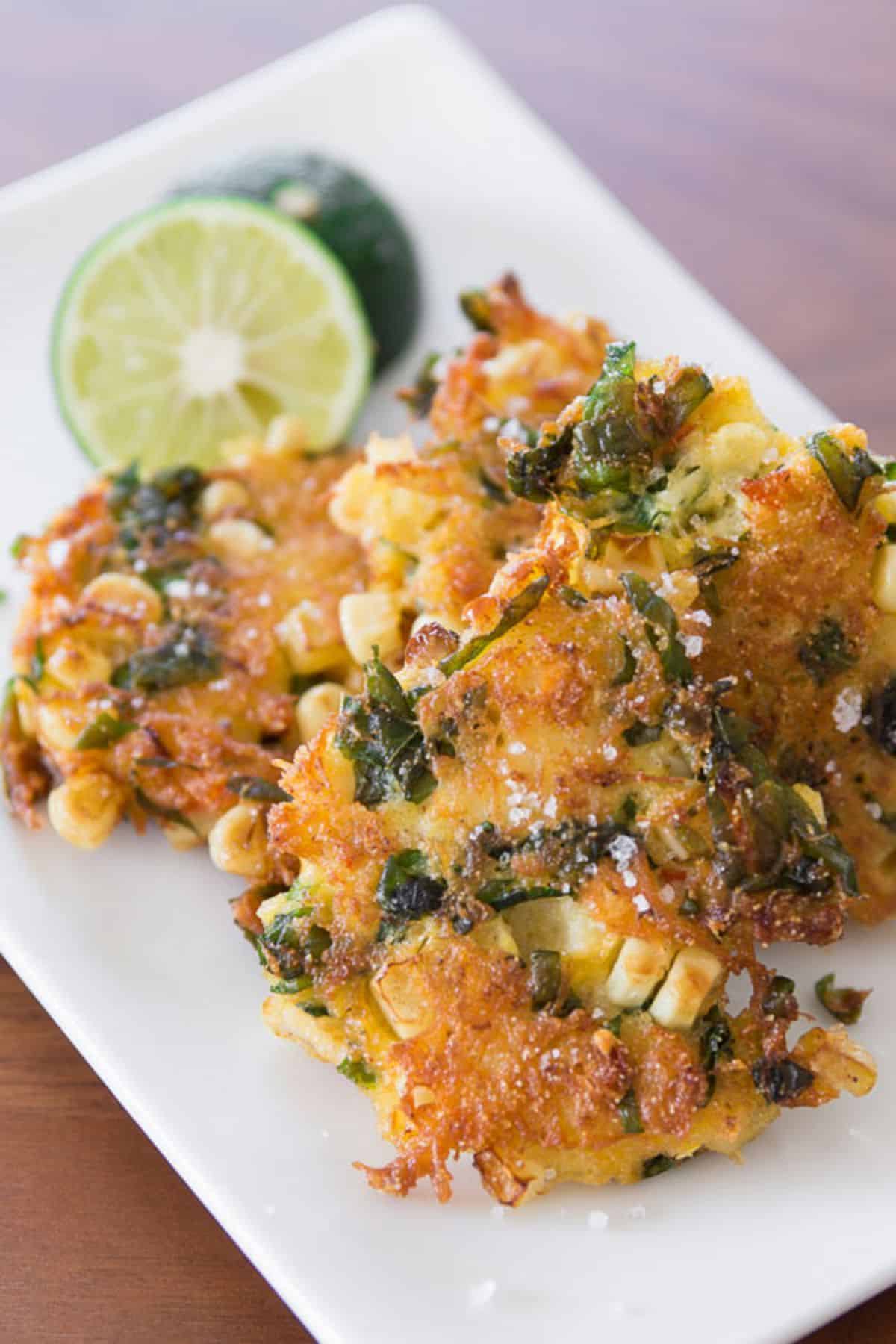 Crispy crab fritters on a white tray.