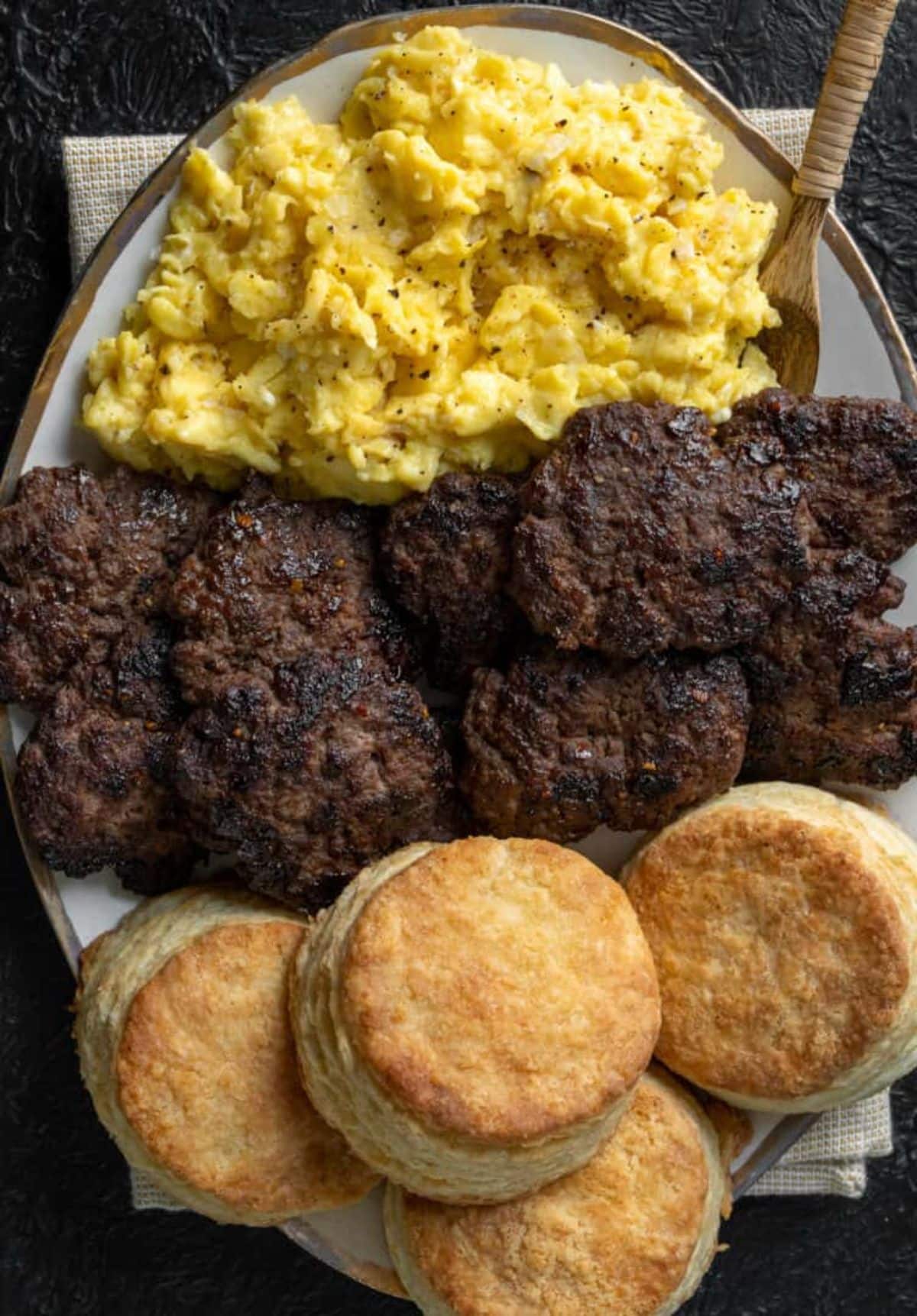 Scrumptious ground bison breakfast sausagewith buns and sauce on a tray.