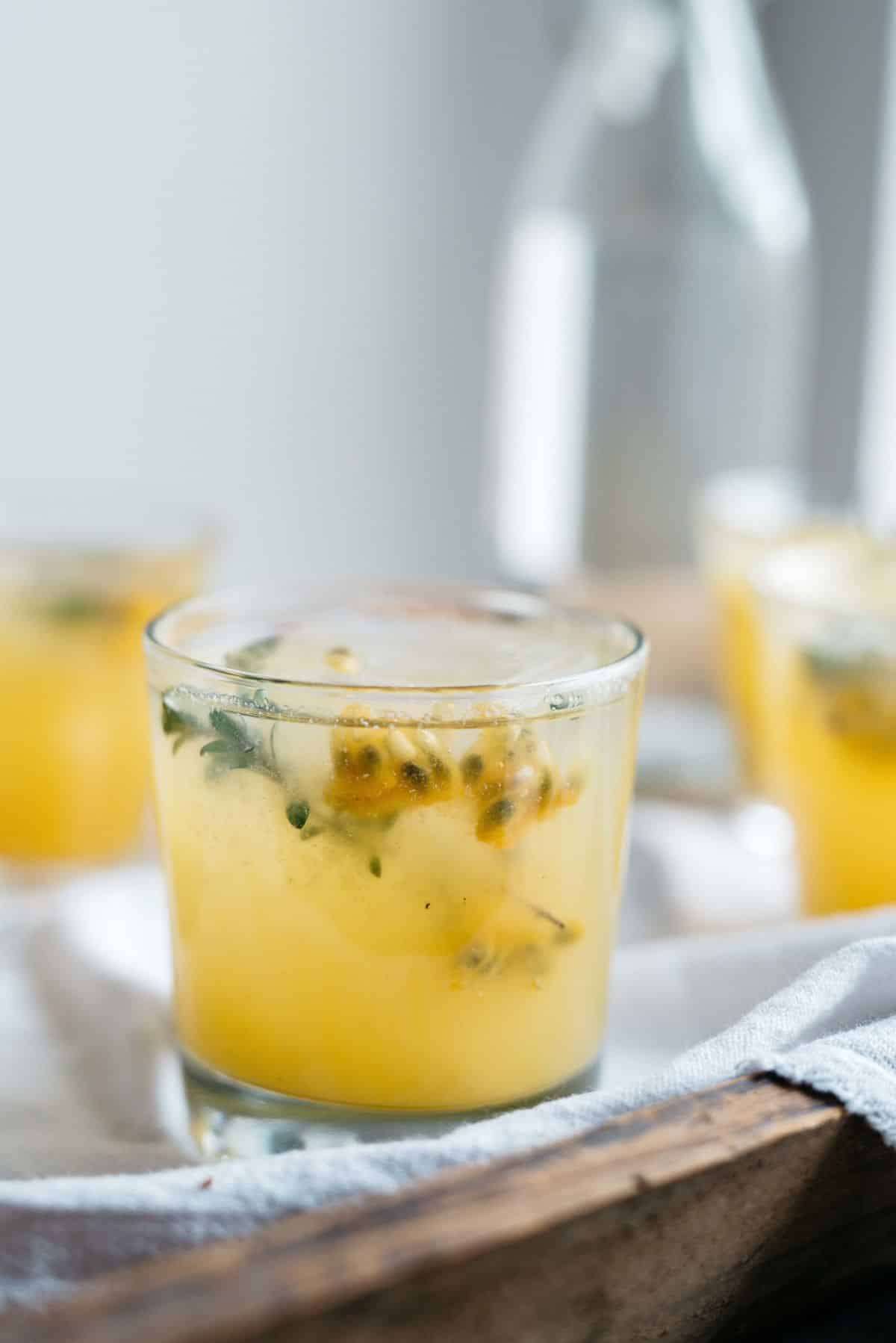 Delicious passion fruit and ginger fresca in a glass cup.