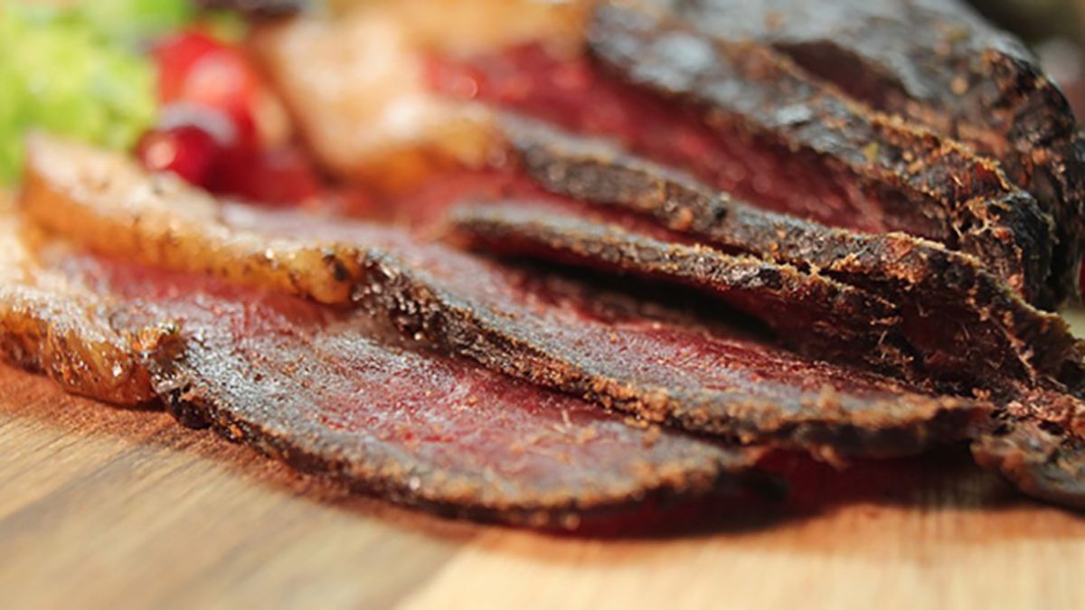 Scrumptious venison jerky on a wooden tray.