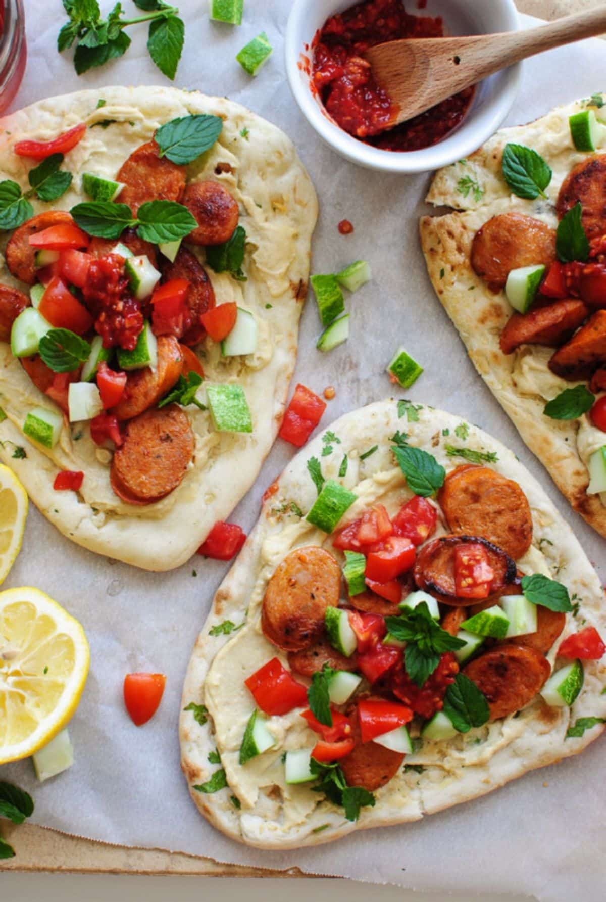 Mouth-watering open-faced greek chicken sausage gyros on a tray.
