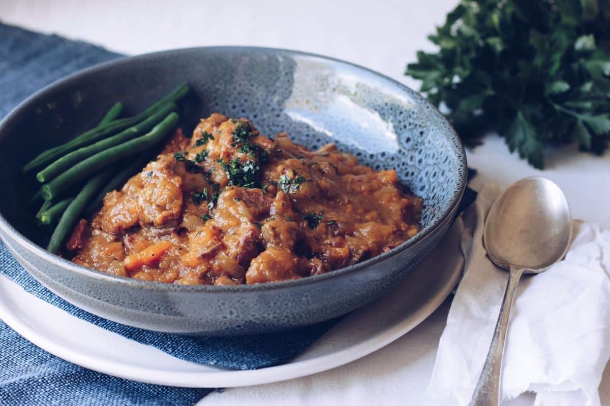 Healthy beef stew with green beans in a gray bowl.