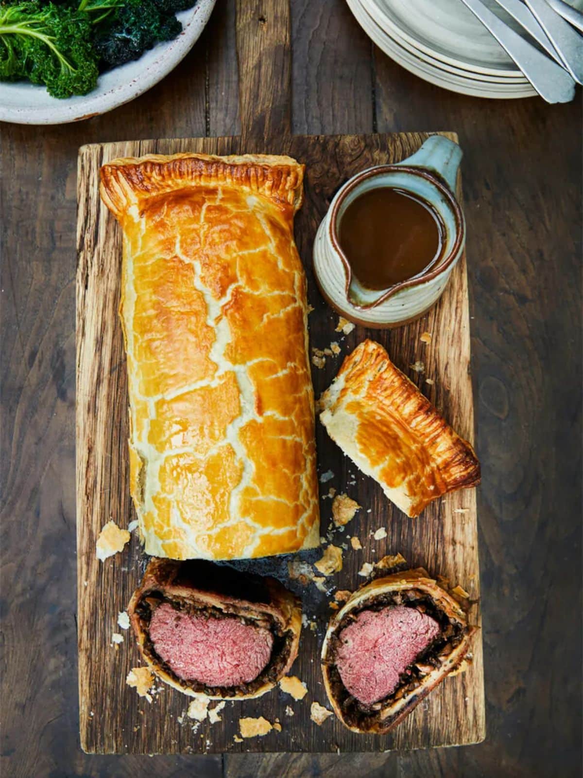 Scrumptious venison wellington with gray on a wooden tray.