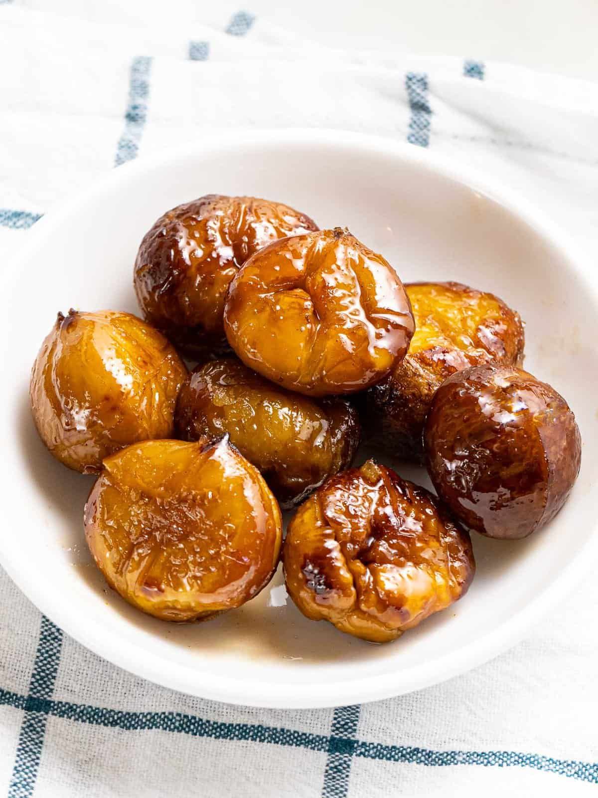 Delicious candied chestnuts in a white bowl.