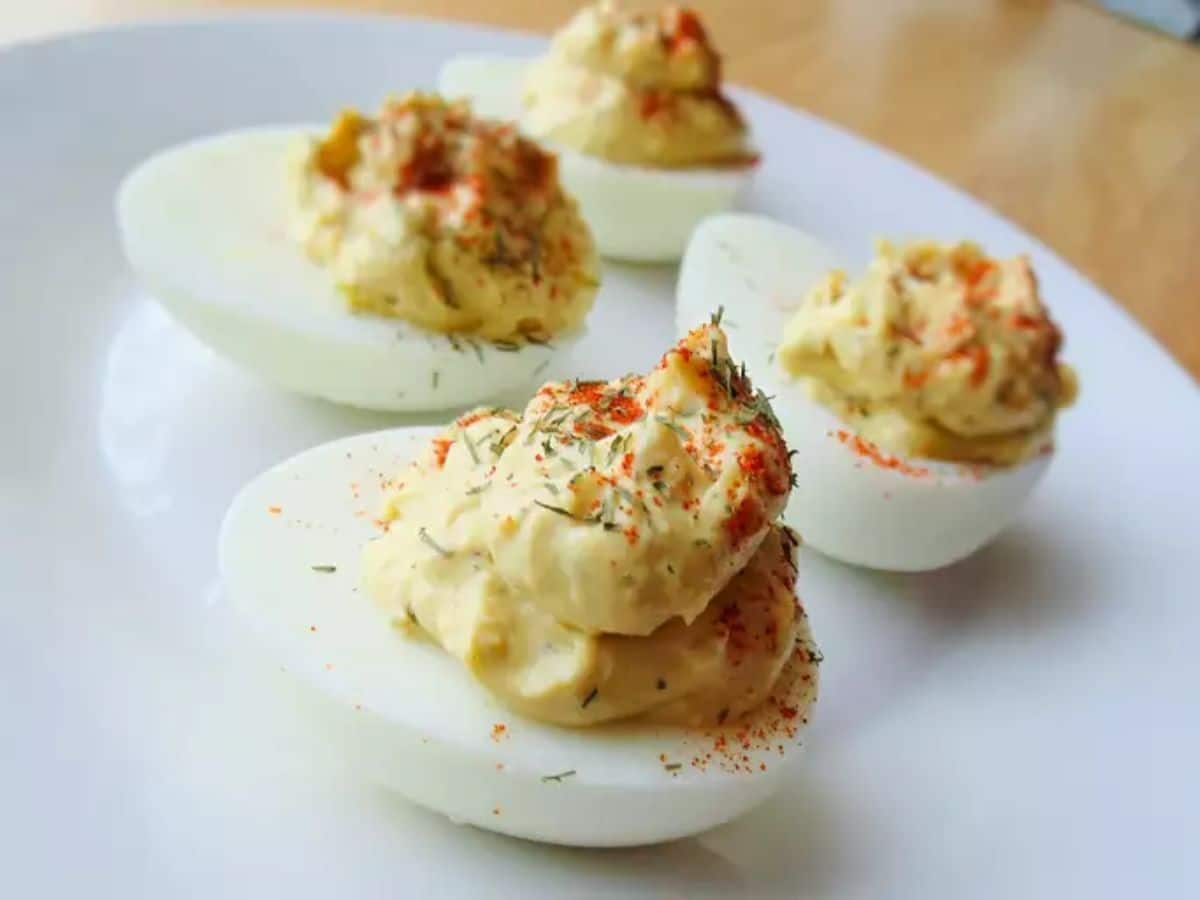 Tasty deviled eggs on a white plate.