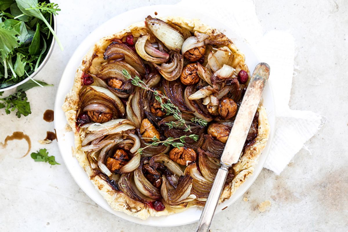 Healthy onion tarte tatin with chestnuts on a tray.