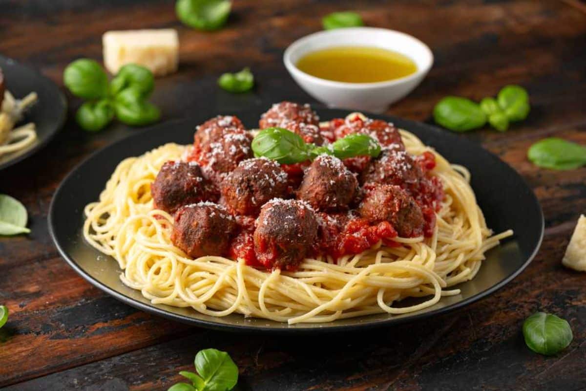 Juicyelk meatballs on a black plate.