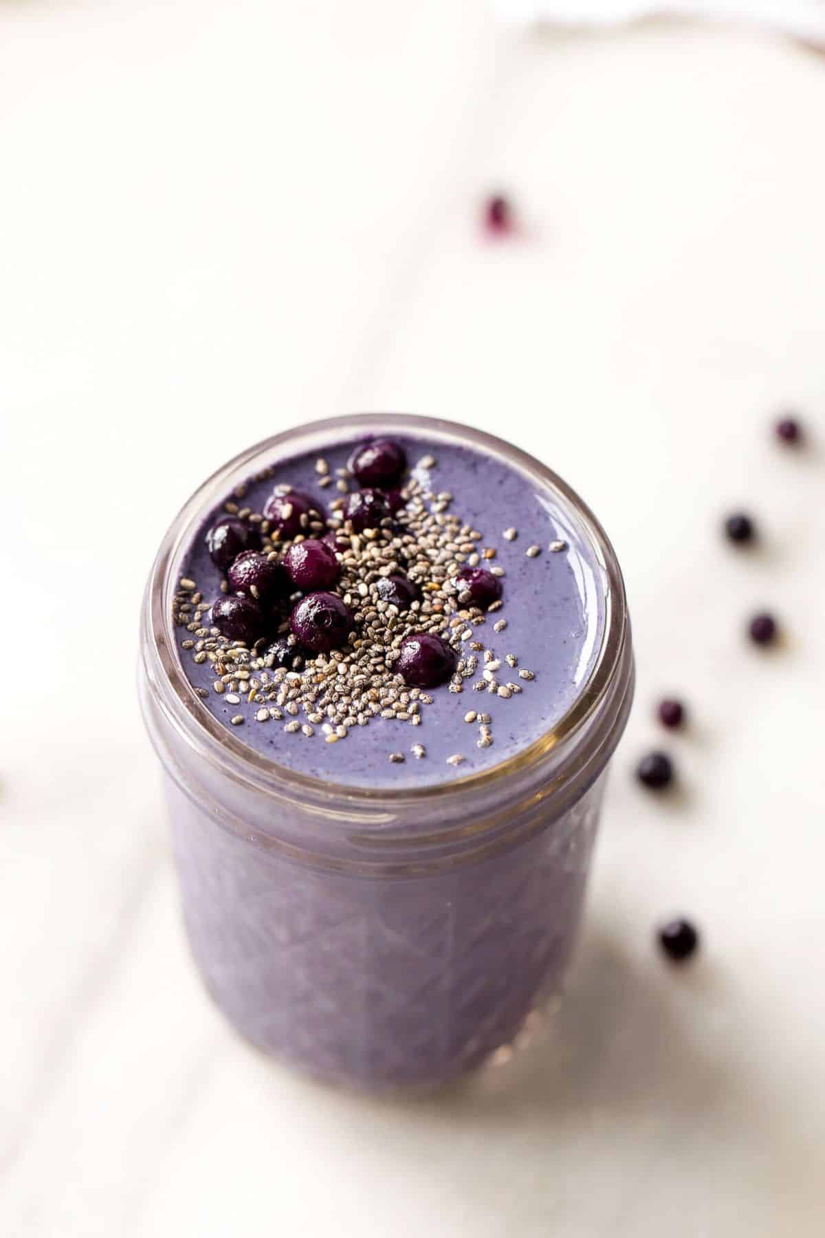 Healthy wild blueberry, brazil nut, & tahini smoothie in a glass jar.