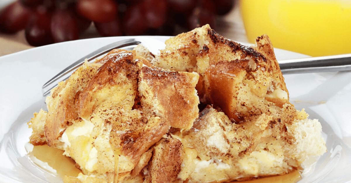 A piece of french toast casserole on a white plate with a fork.