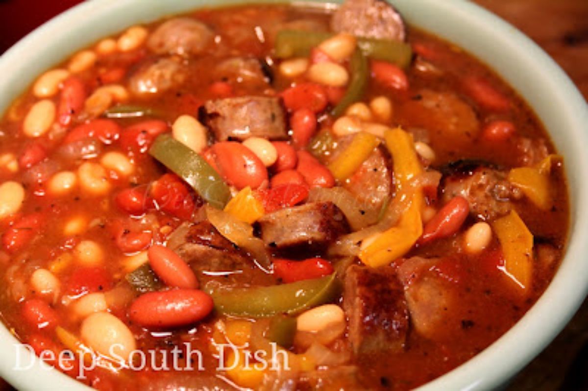 Mouth-watering sausage and peppers stew in a white bowl.