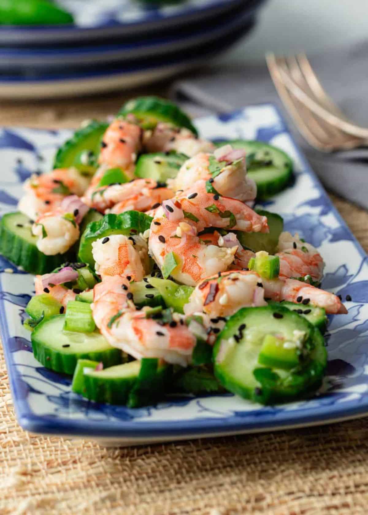 Healthy shrimp cucumber saladon a blue tray.