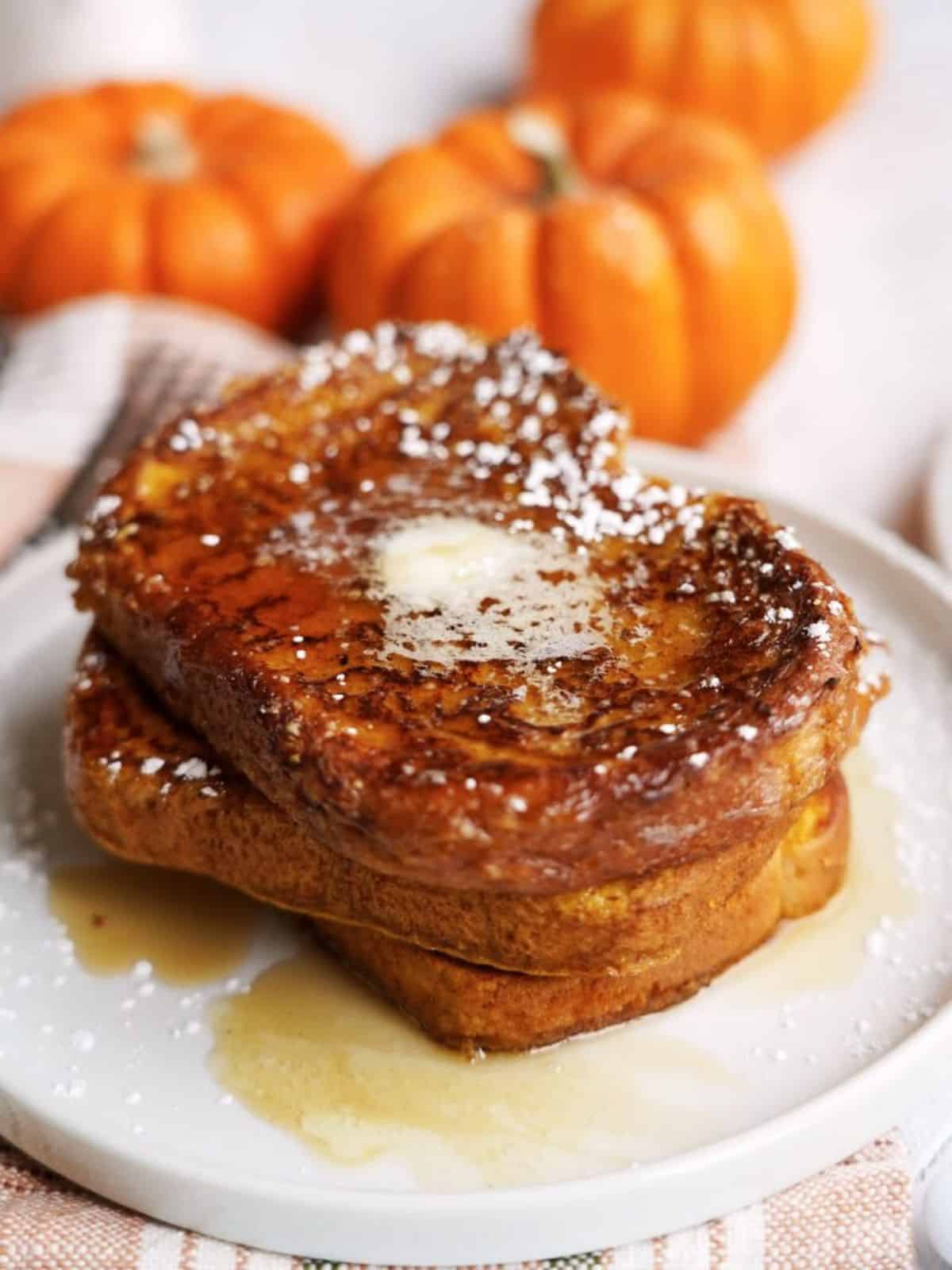 Three pumpkin french toast on a white plate.