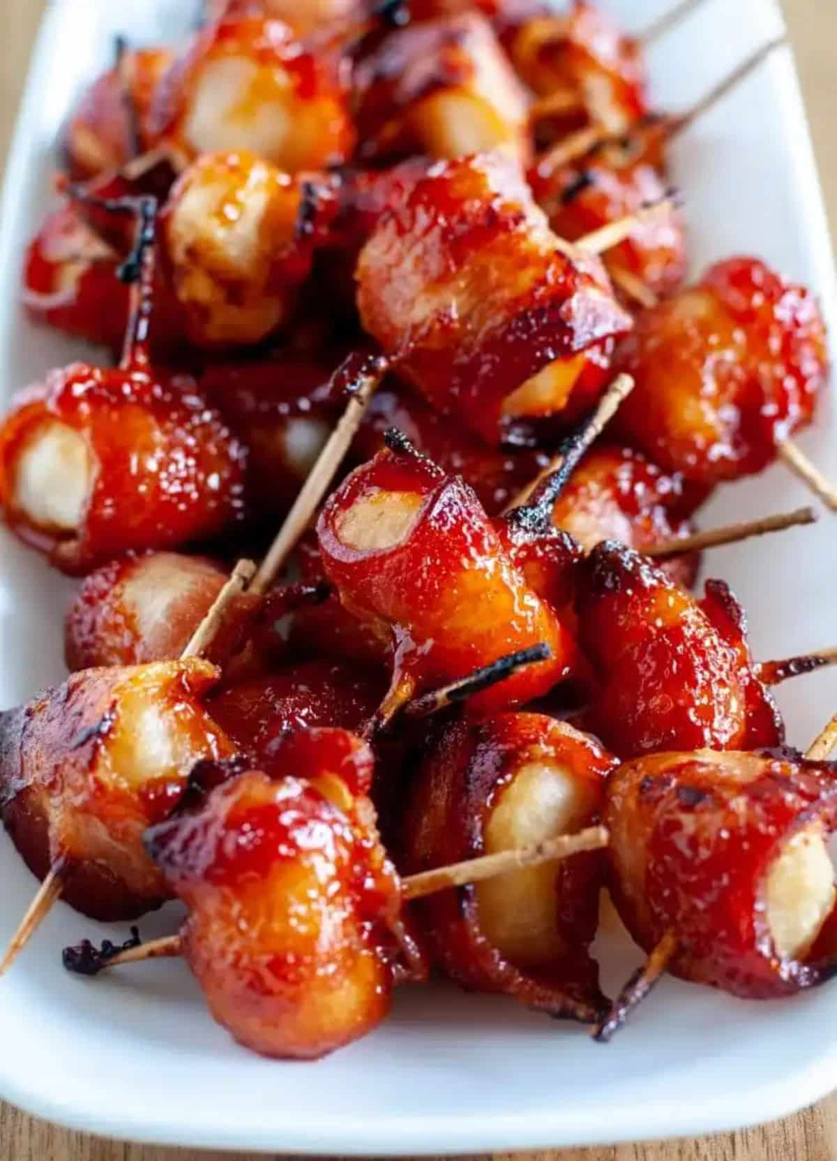 Juicy bacon-wrapped water chestnutson a white tray.