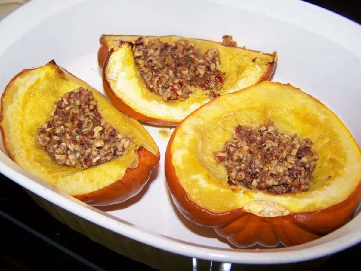 Tasty acorn squash with spiced brazil nut filling in a white bowl.