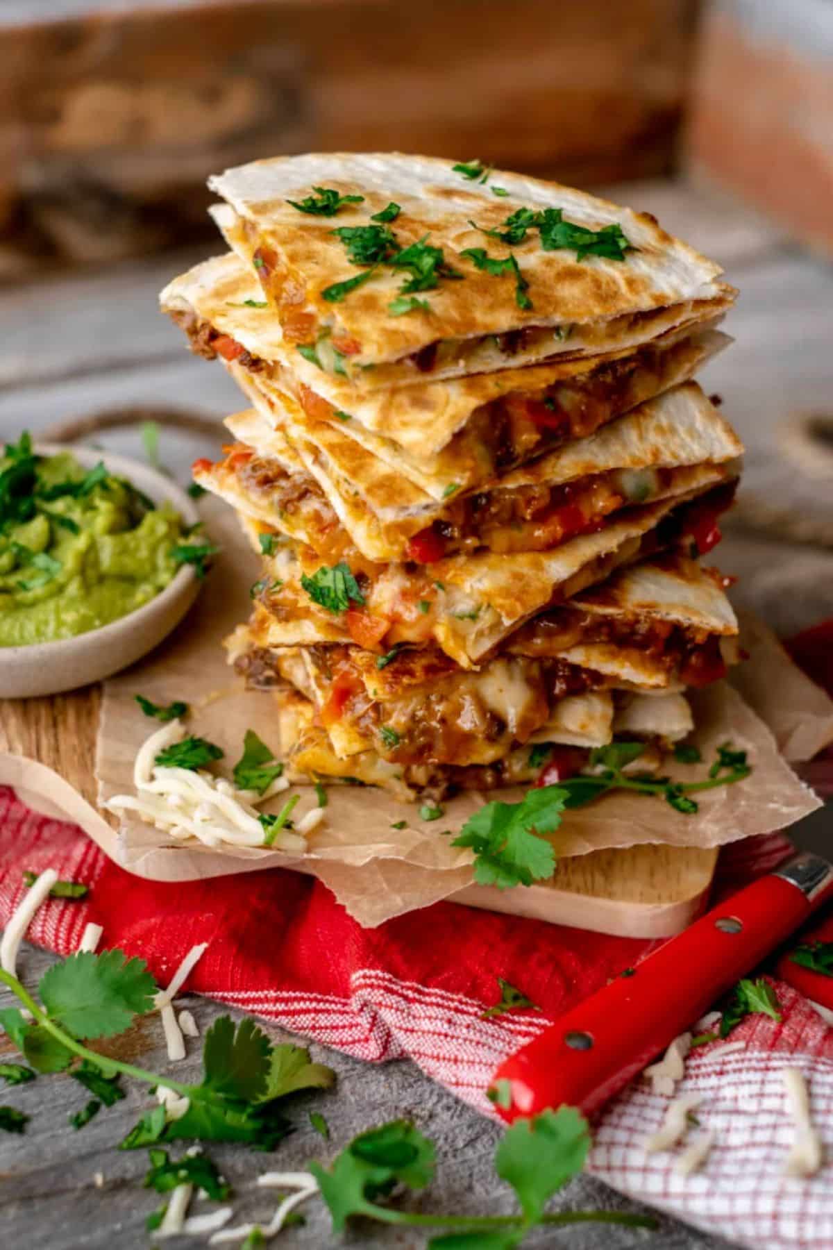 A pile of ground elk quesadillas on a table.