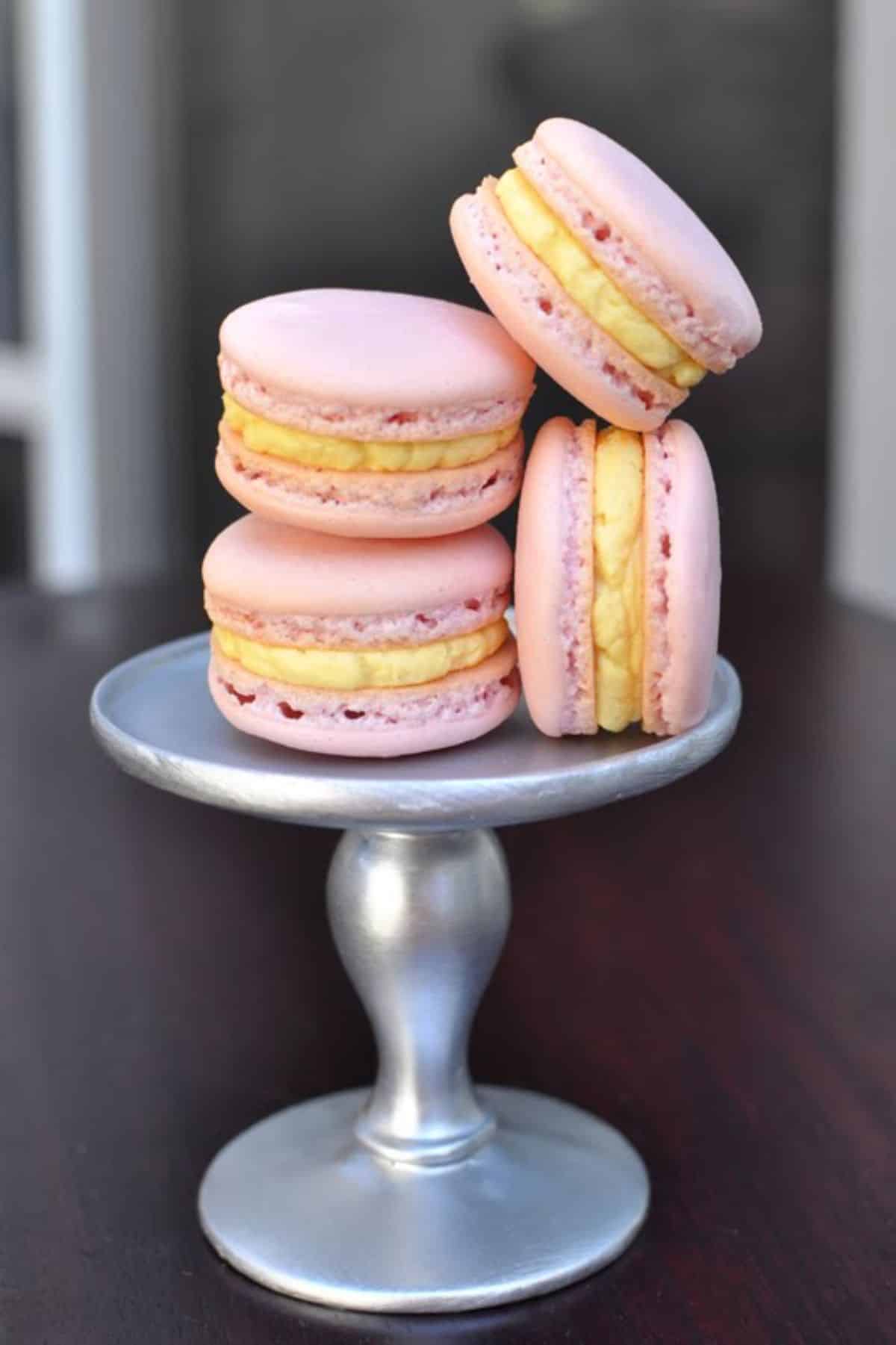 Mouth-watering passion fruit macarons on a cake tray.