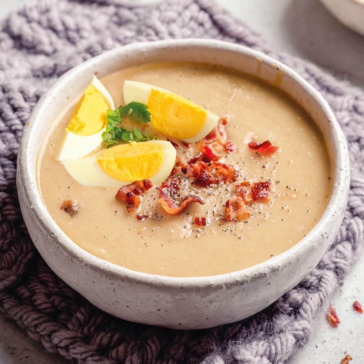 Creamy  chrzanowa: polish horseradish soup with bacon & egg in a bowl.