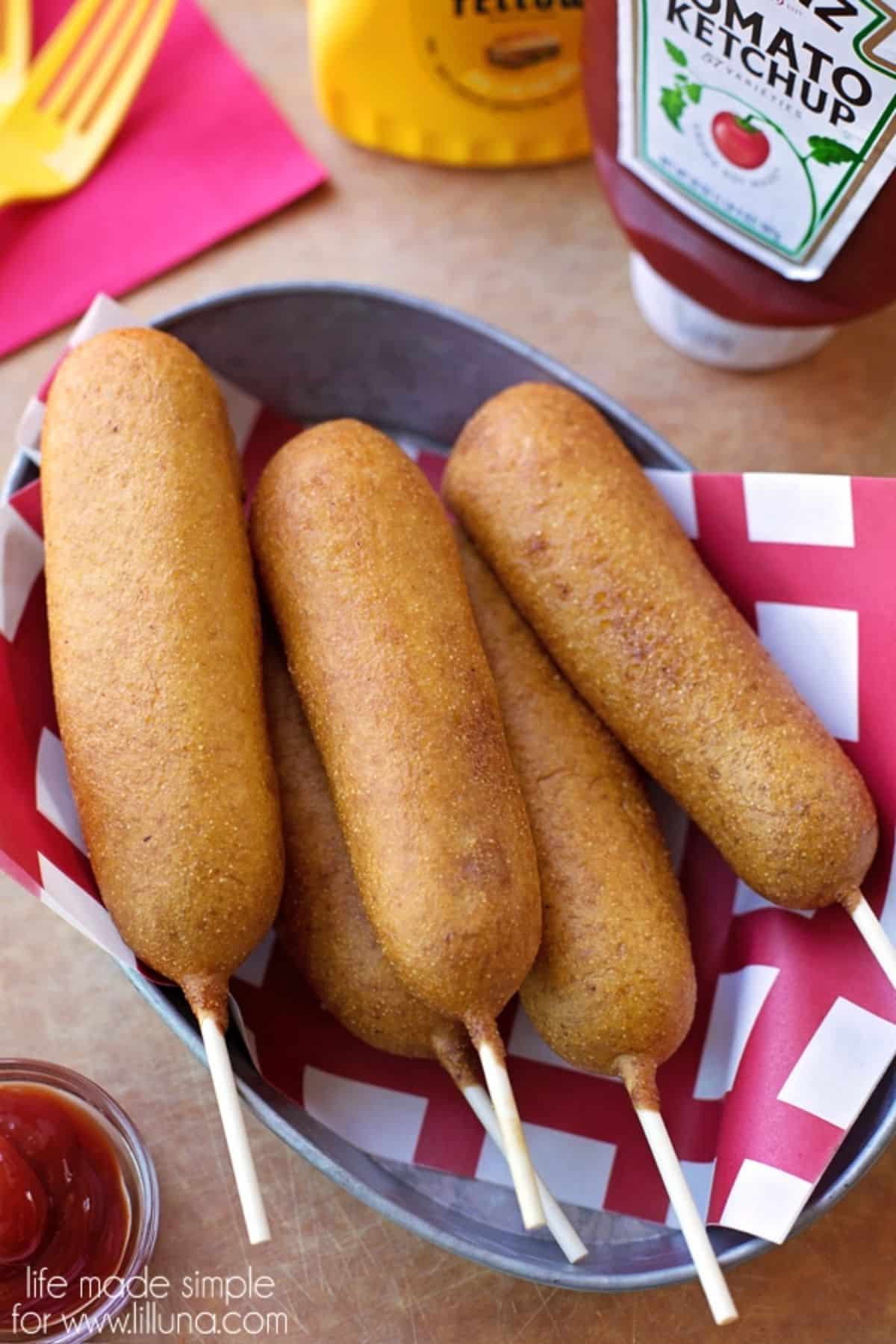 Crispy corn dogs in a gray bowl.