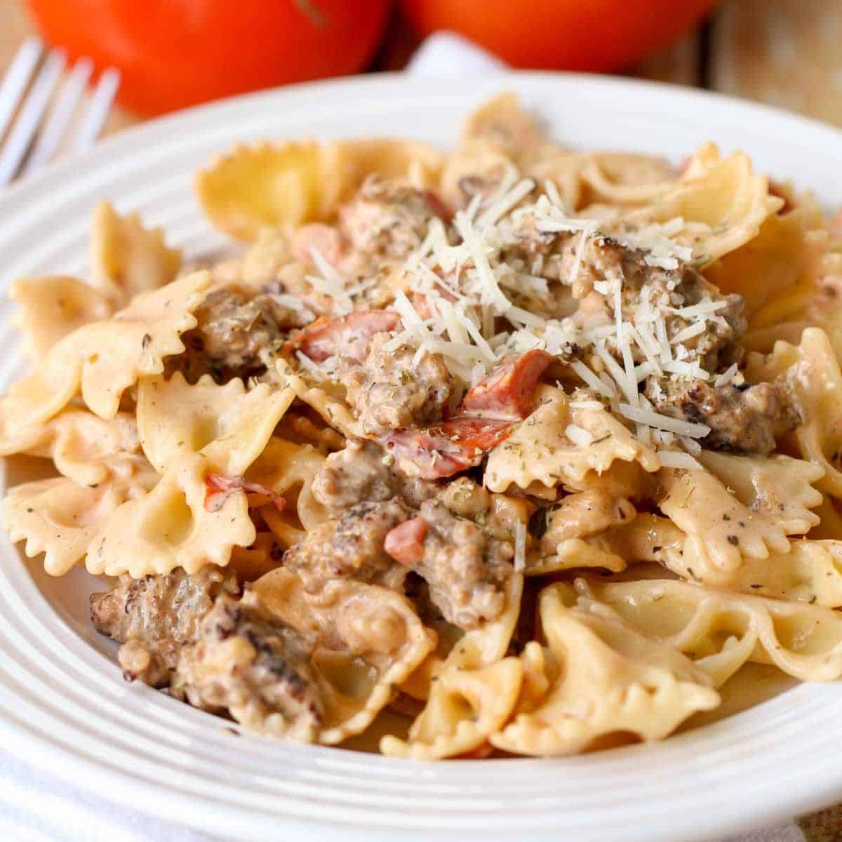Healthy italian sausage pasta on a white plate.