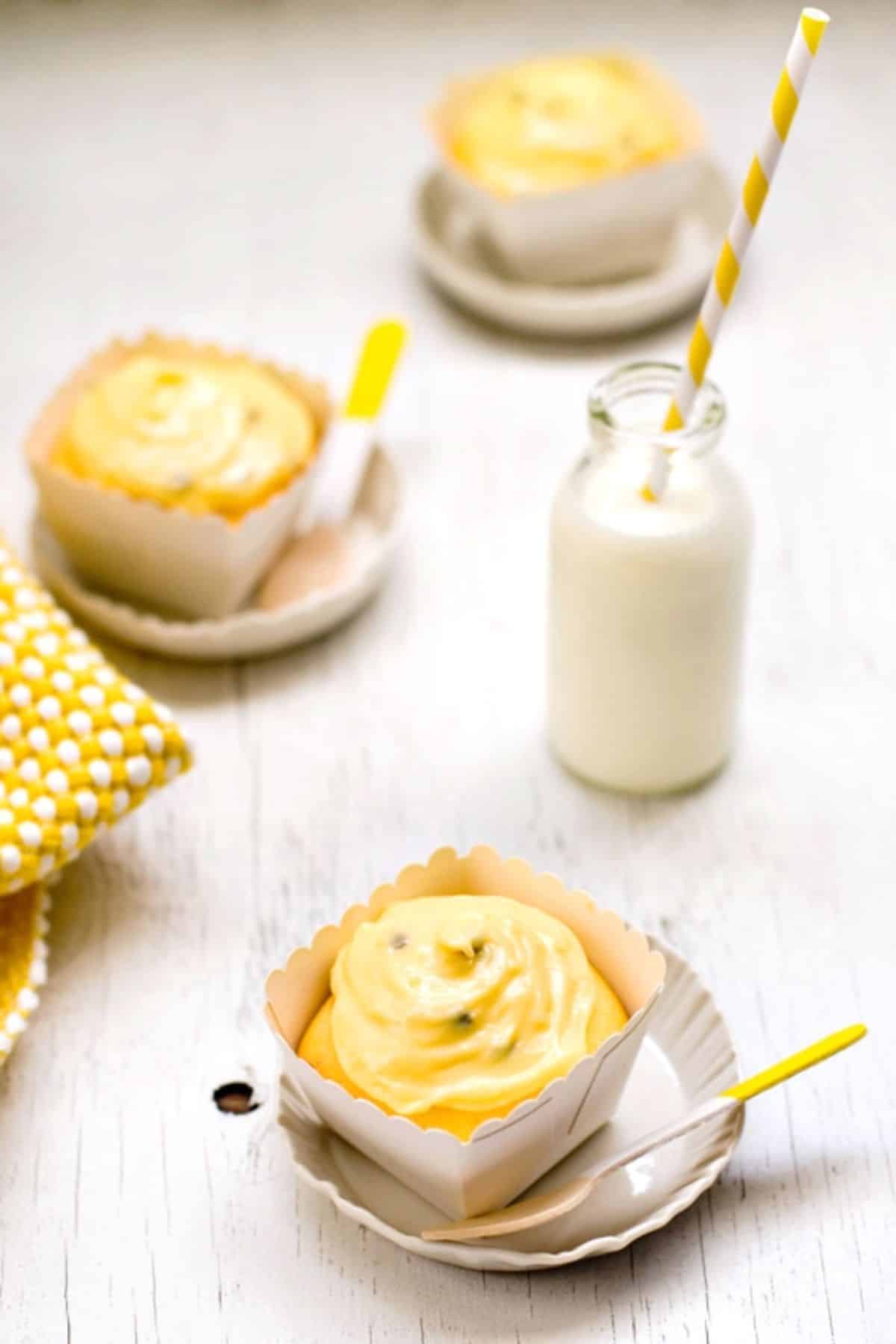 Delicious passion fruit cupcakes on a wooden table.