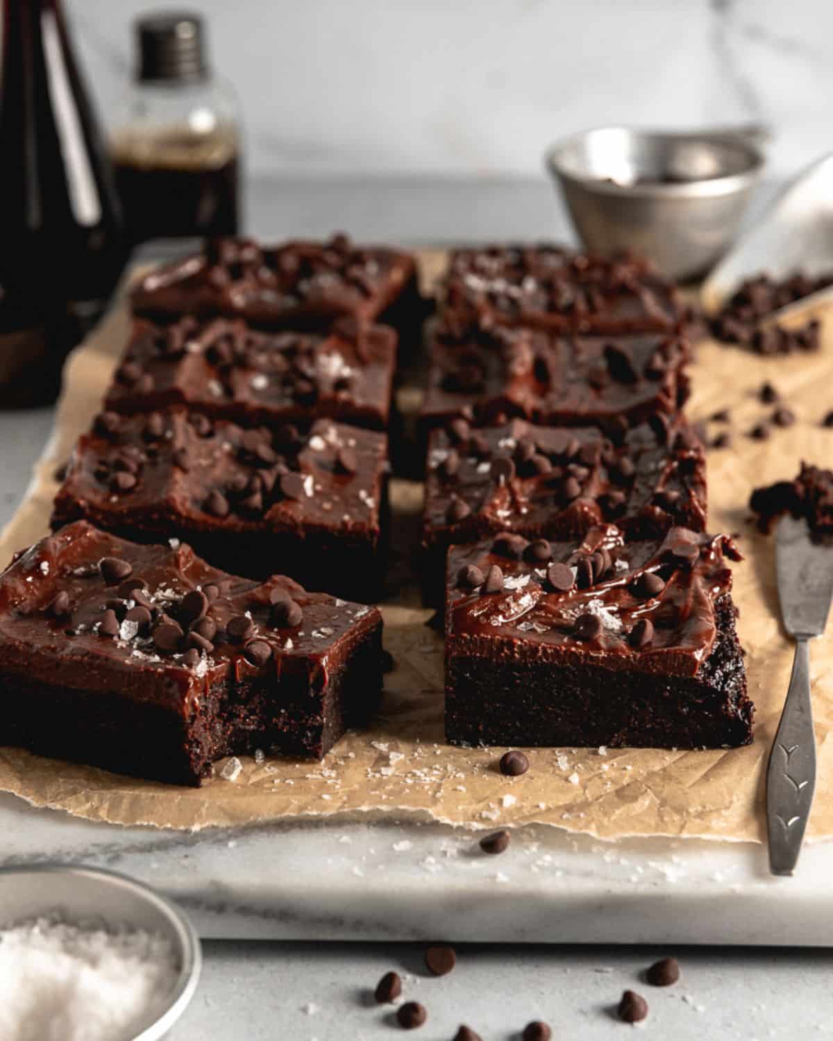 Flavorful fudgy vegan tofu brownies with tofu ganacheon a tray.