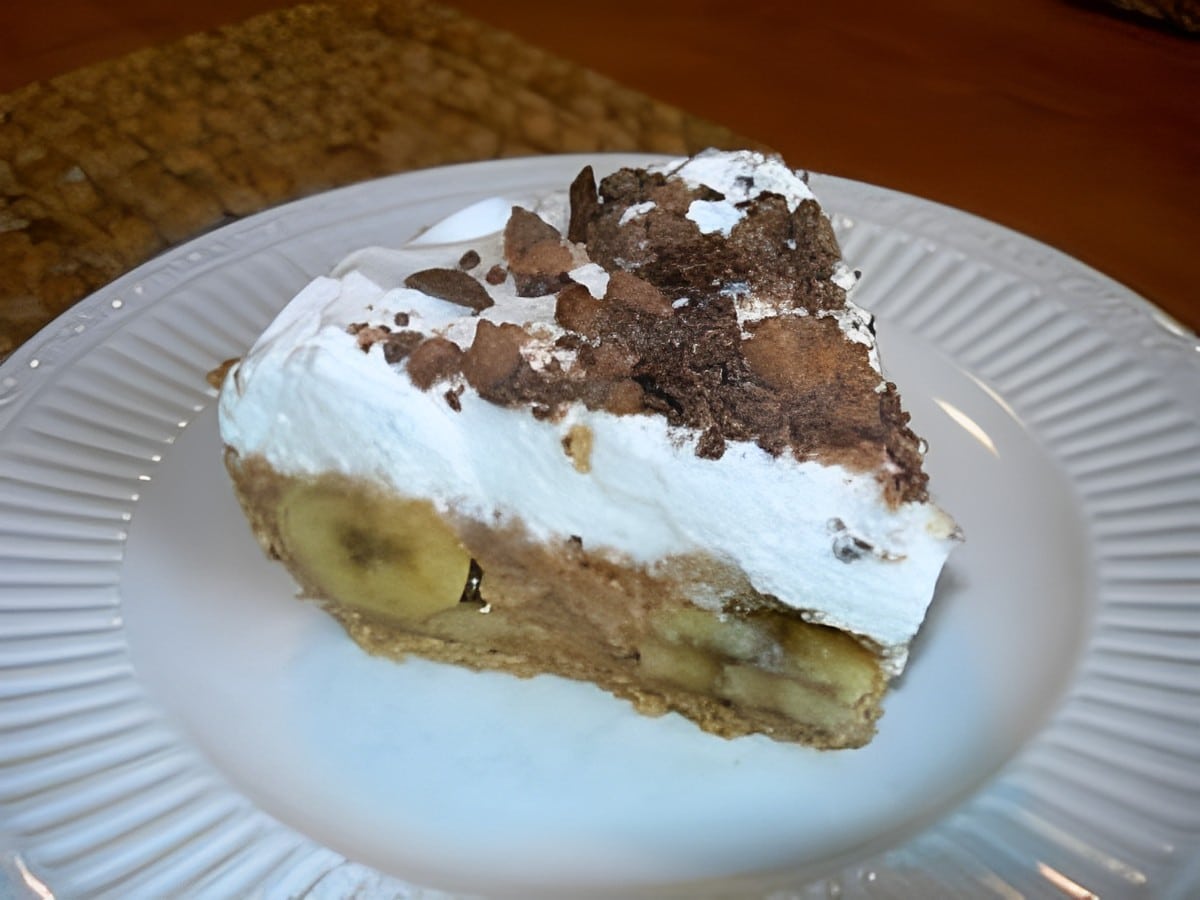 A piece of banana heath bar pie on a white plate.