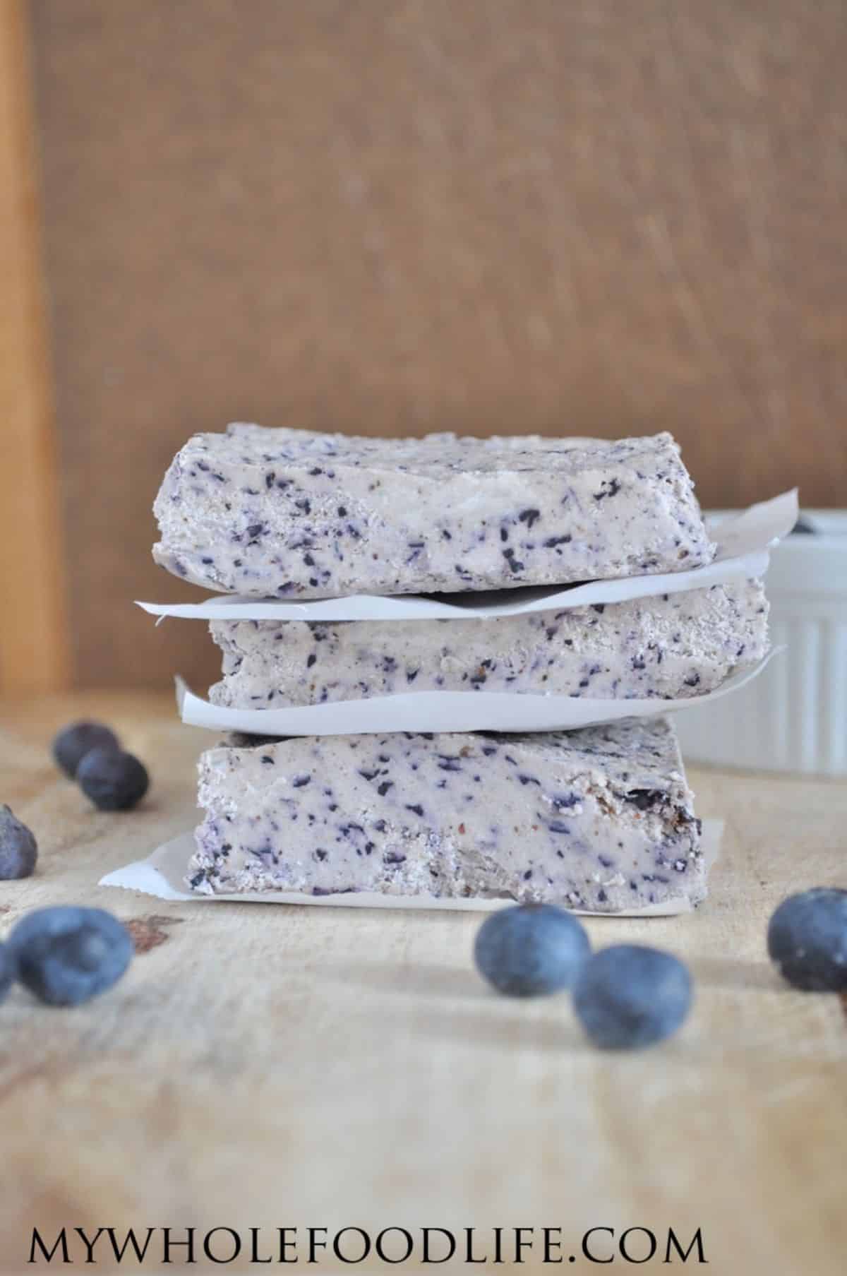 A pile of blueberry bliss bars on a wooden table.