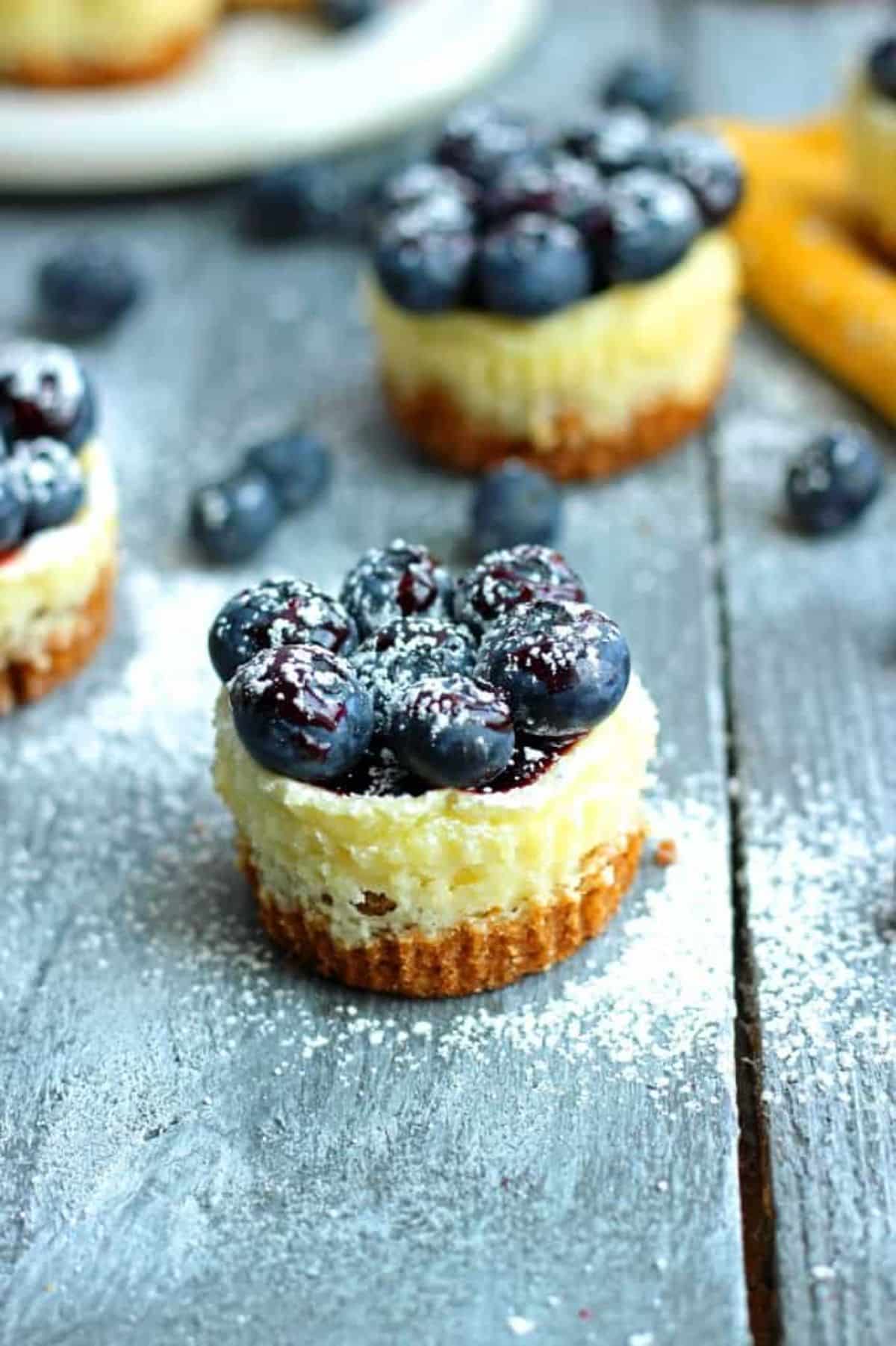 Scrumptious blueberry cheesecakes on a wooden table.